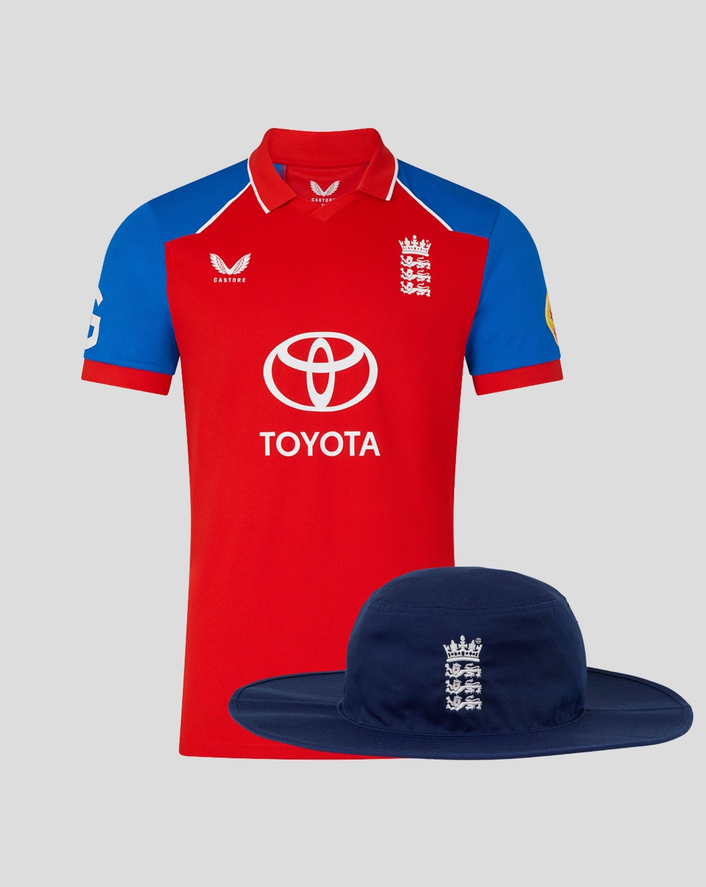 England 26/27 T20 shirt in red with blue sleeves shown with a navy brim hat featuring the Three Lions crest
