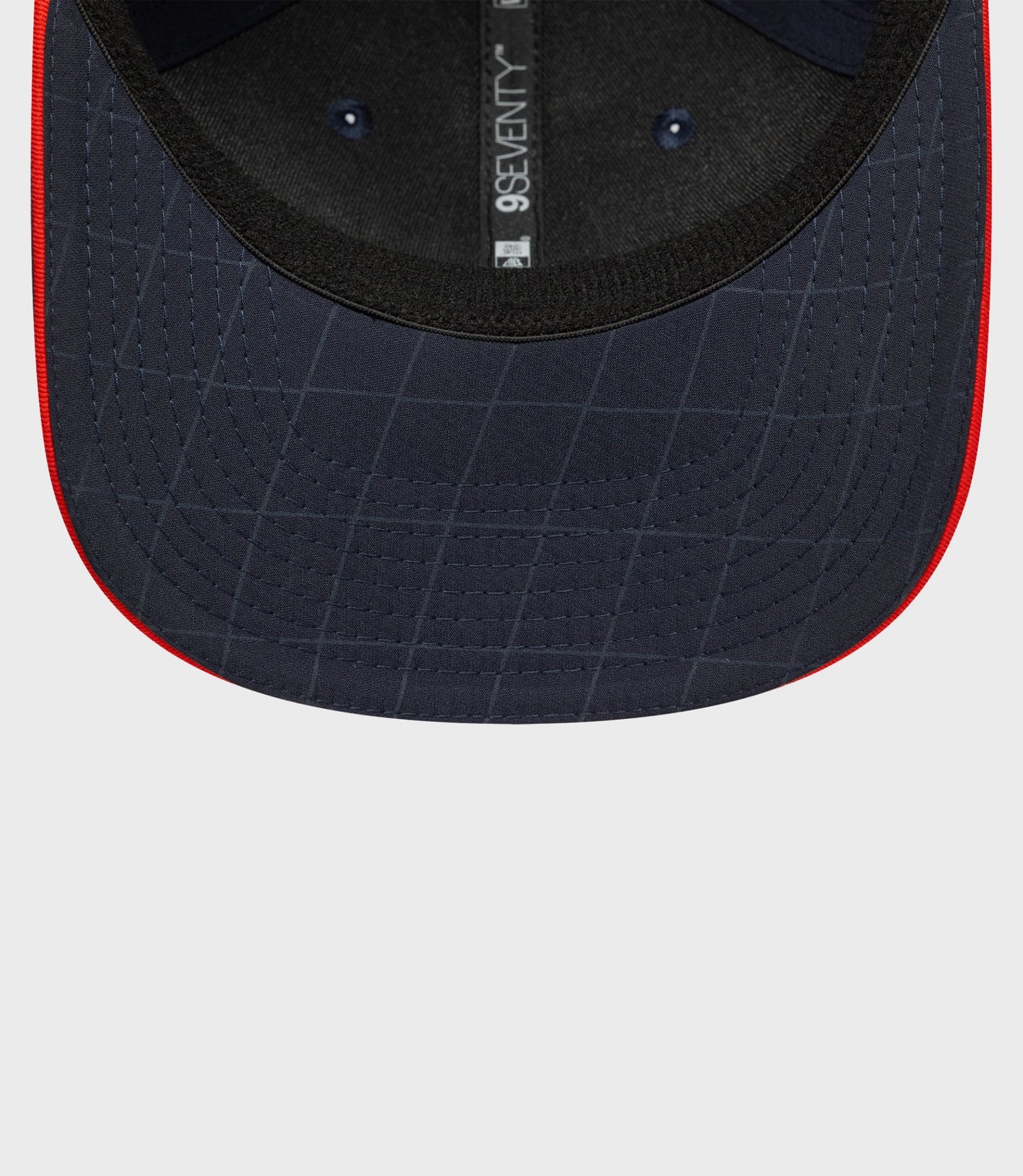 Back interior view of navy blue cap with adjustable strap and 9Seventy label along the back seam.