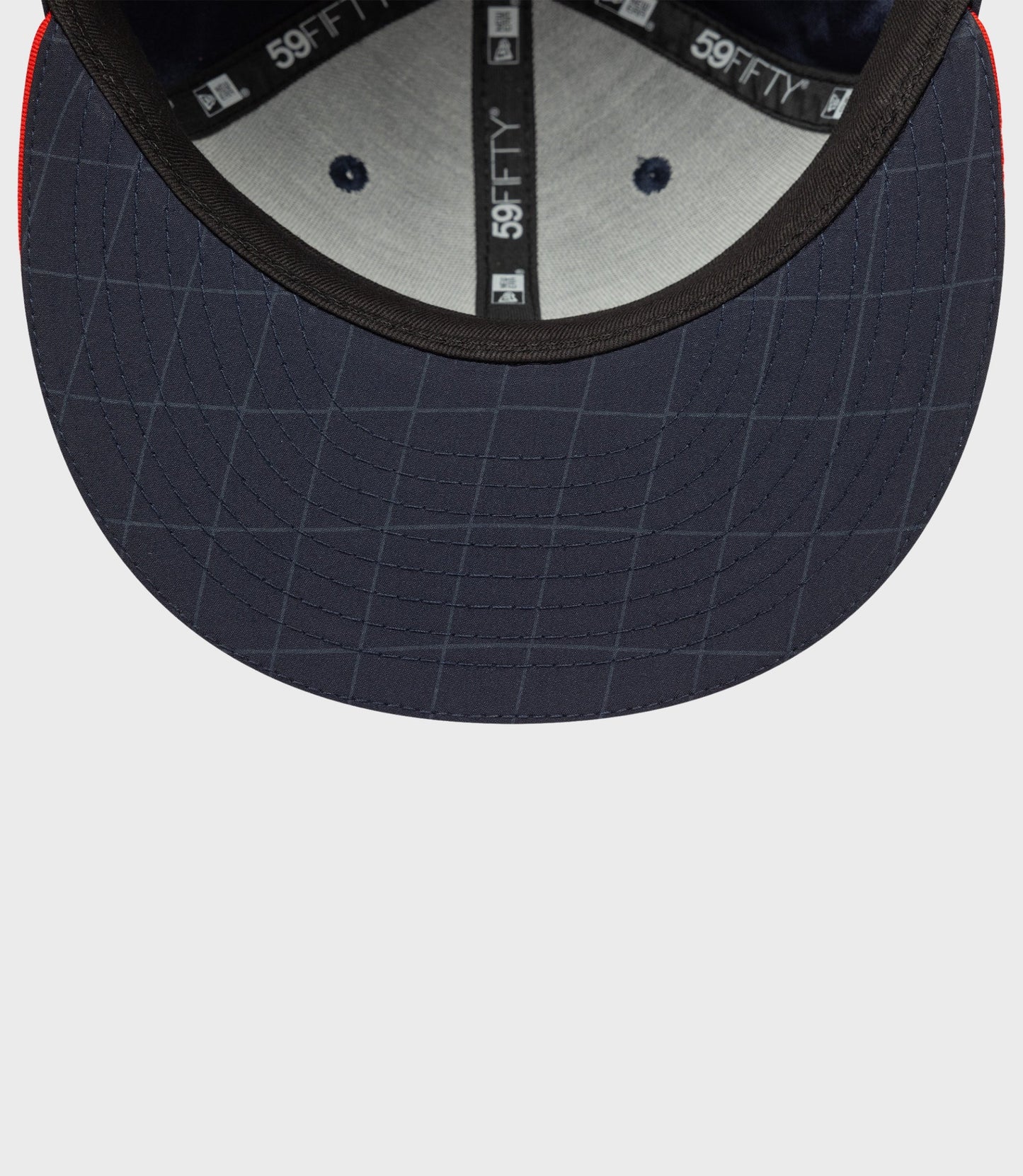 Interior view of navy blue 59FIFTY cap showing under brim stitching and inner branding tape.
