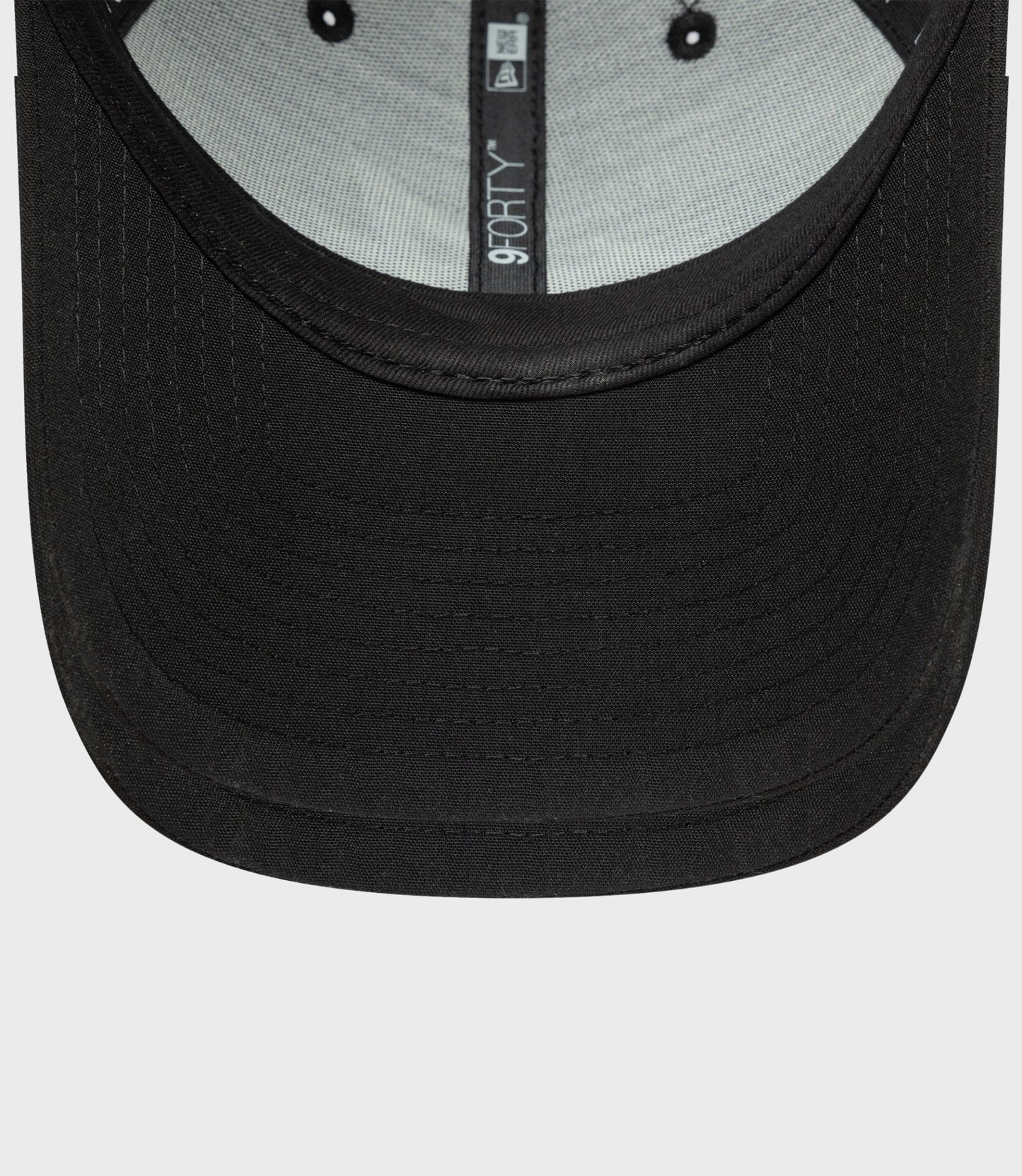 Close-up of black New Era Estretch Snapential 9Forty cap showing curved brim and inner 9FORTY label
