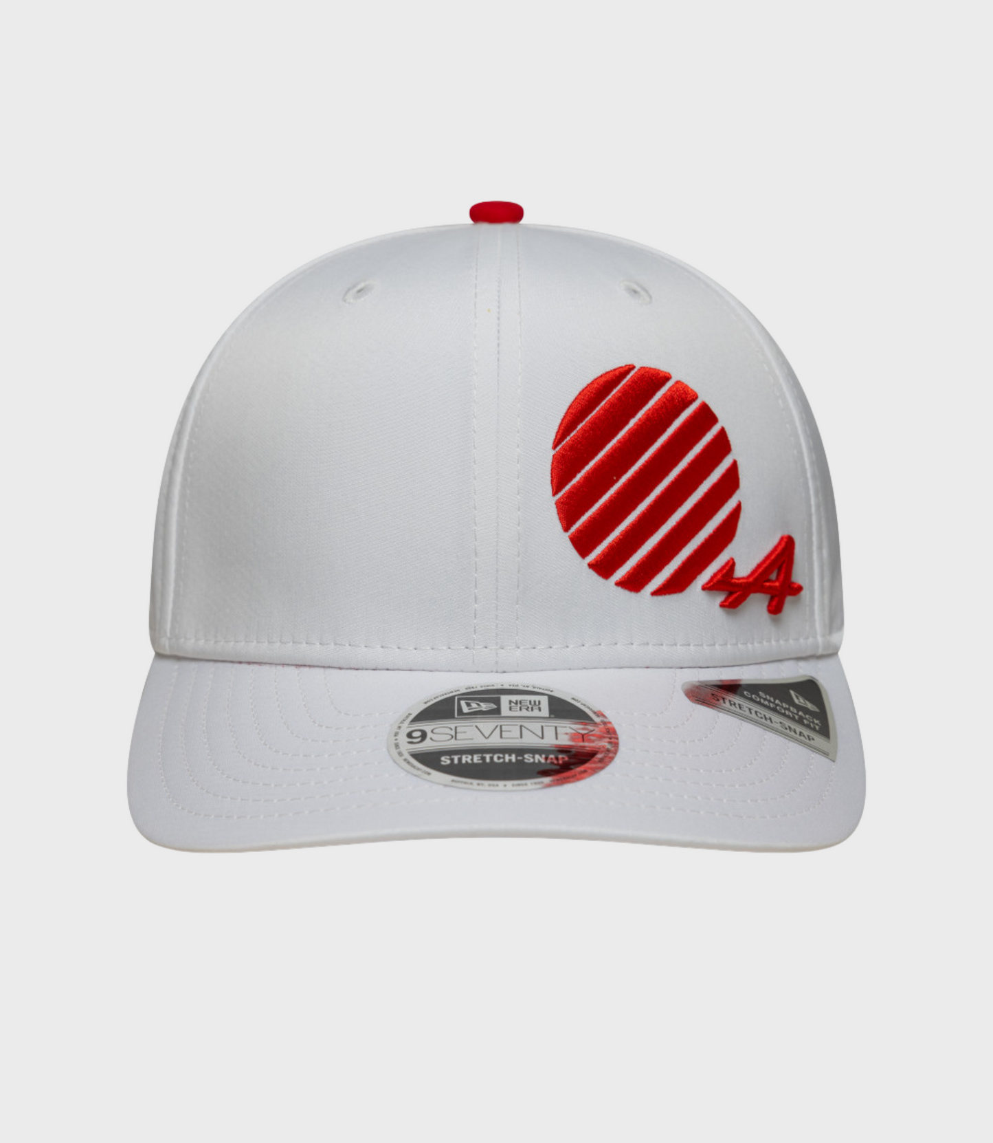 White cap viewed from above with a red crown button and partial red embroidered patch on the front