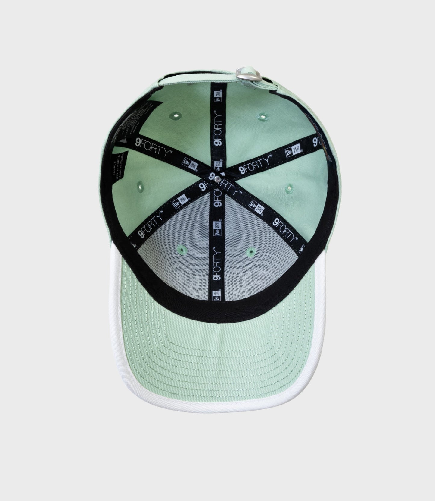 Inside view of pastel green New Era 9FORTY cap showing taped crown and interior stitching.