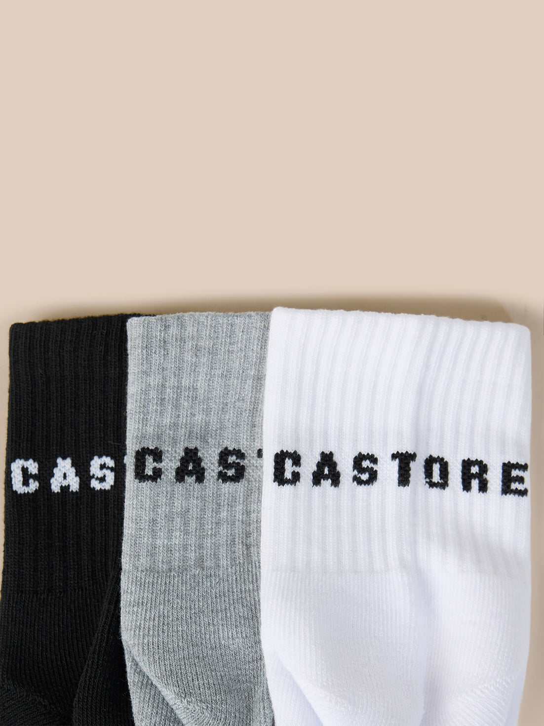 Three pack of Castore Druce quarter socks in black gray and white with bold Castore lettering
