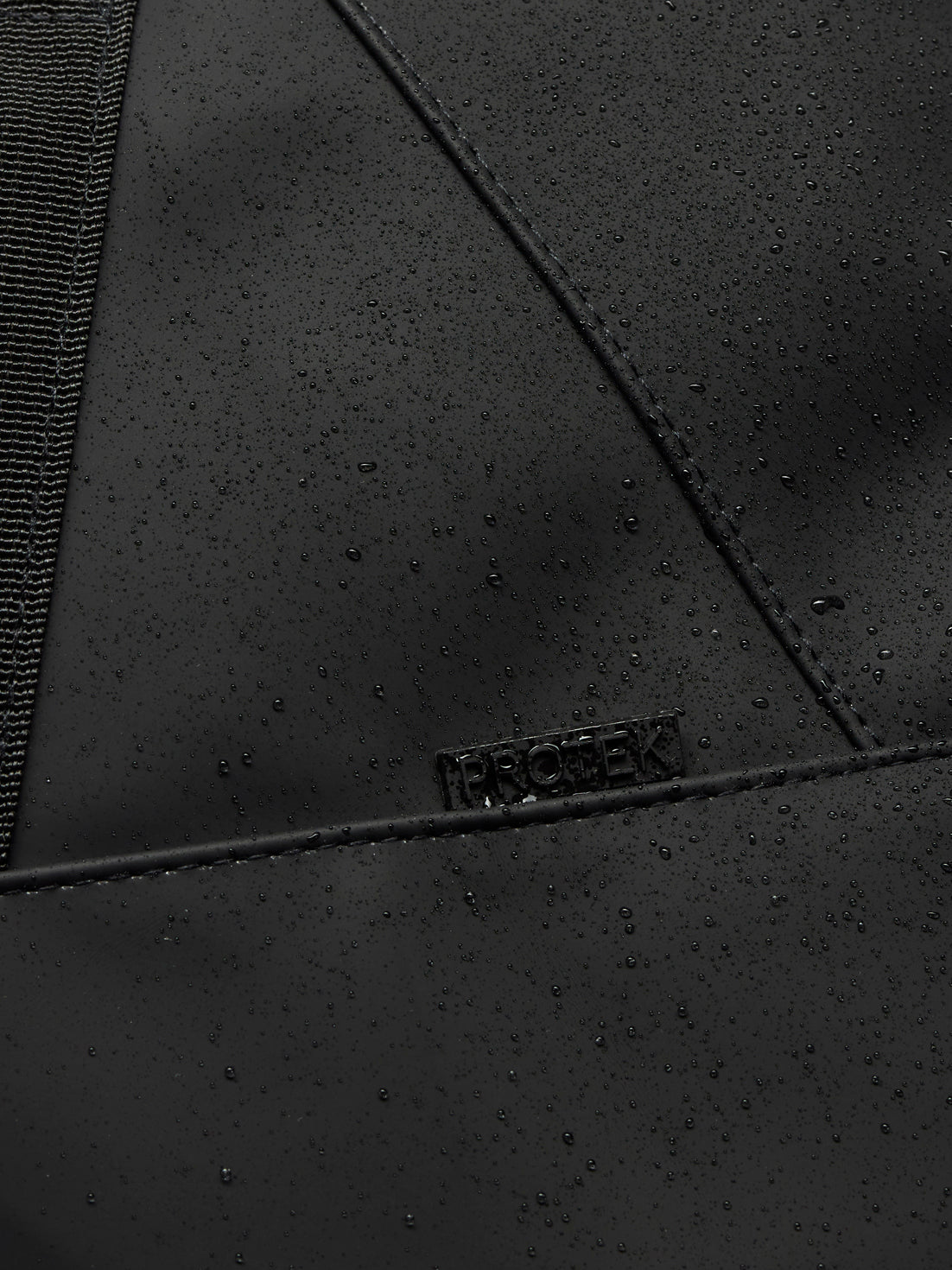 Close up of black ProTek water resistant fabric with droplets on a holdall panel