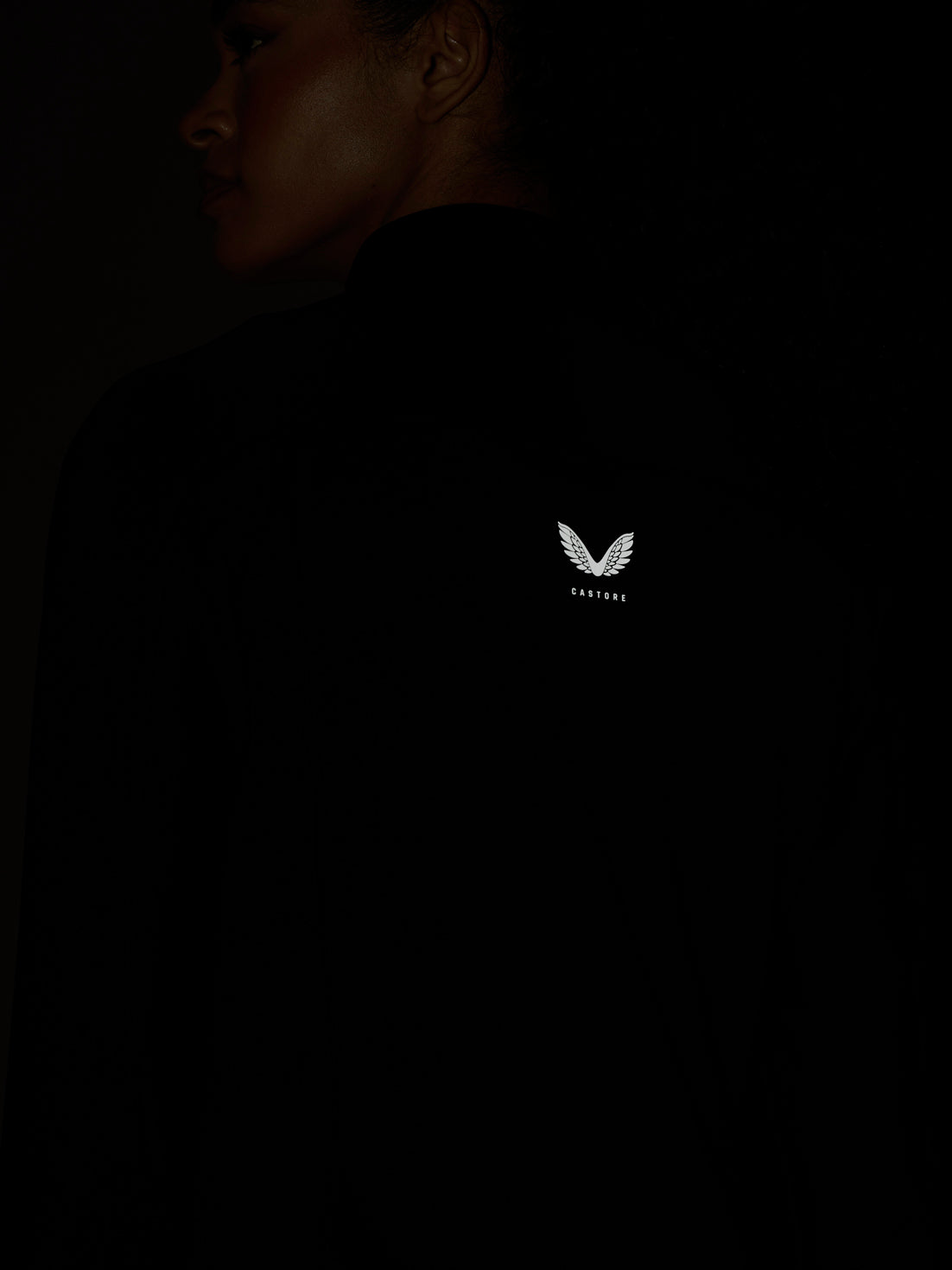 Back view of a black Zone Training Top with a white Castore wing logo on the upper back