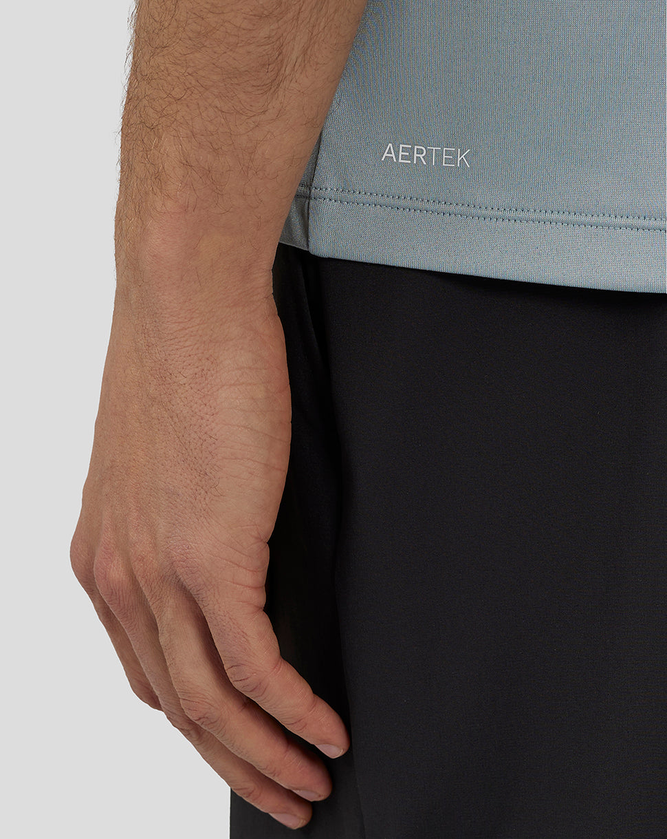 Back view of a man in a stone blue engineered knit T shirt with Aertek branding stripe along the back