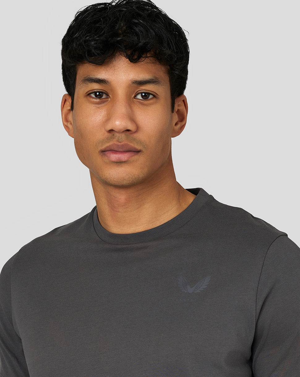 Close-up of a model wearing a dark gray Crew neck T-shirt with a minimalist left chest logo.