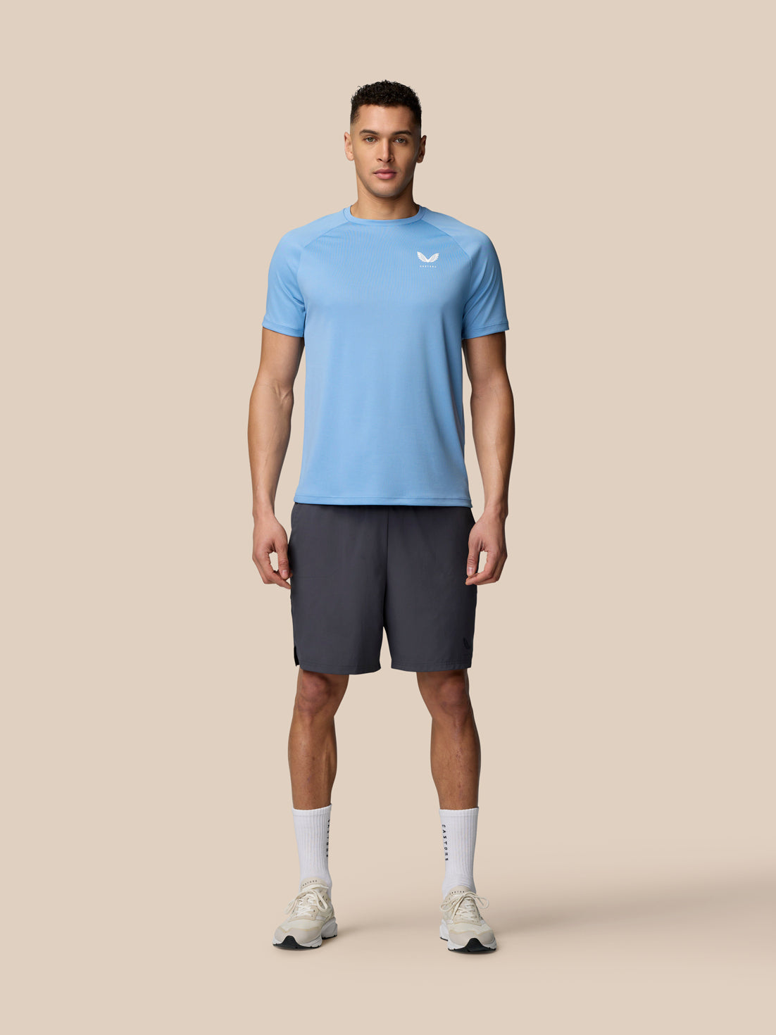 Male model wearing sky blue Adapt Training T Shirt with raglan sleeves and chest logo.