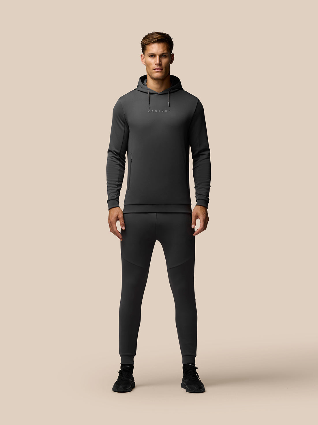 Male model in Charcoal Flex Thermo Joggers and hoodie with CASTORE logo on the chest.