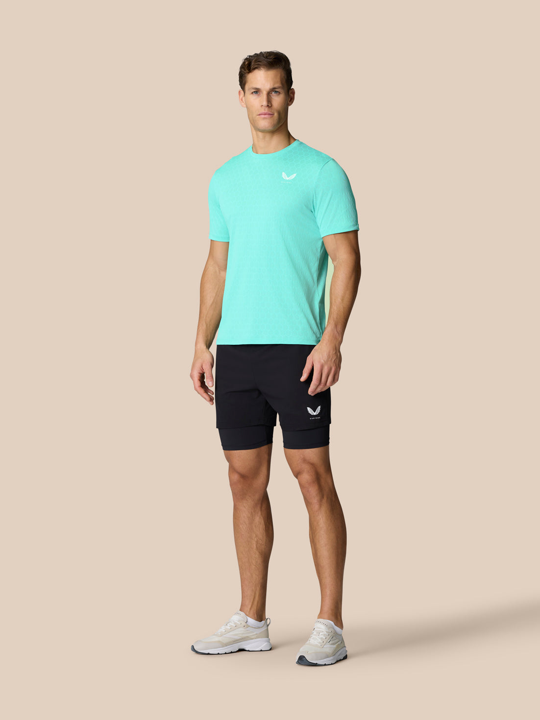 Male model in Flow Training T Shirt Light Aqua with black shorts front view, showcasing the crew neck and breathable knit