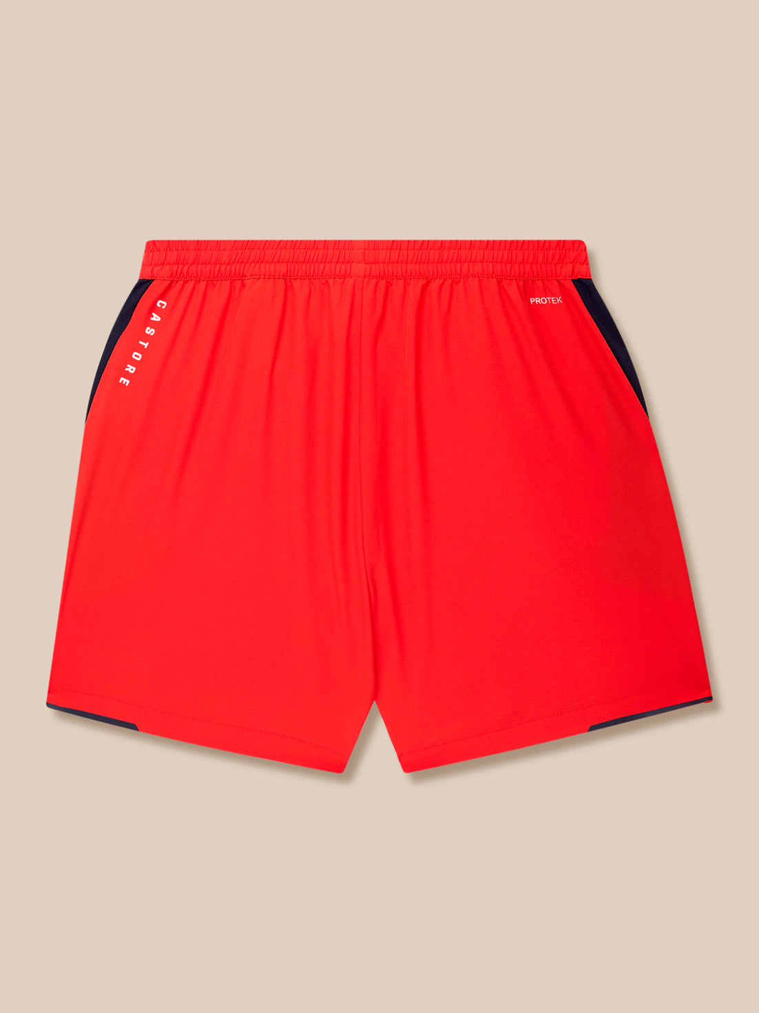 Red training shorts with navy side panels, Castore branding along the left leg and Protek text at the waistband.