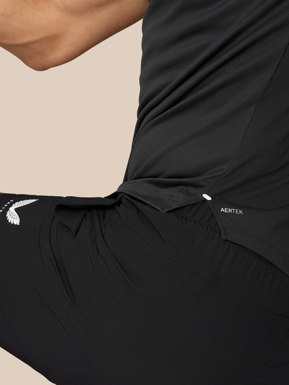 Close up side view of black Flow Muscle Grip T Shirt showing textured fabric and AerTek label.