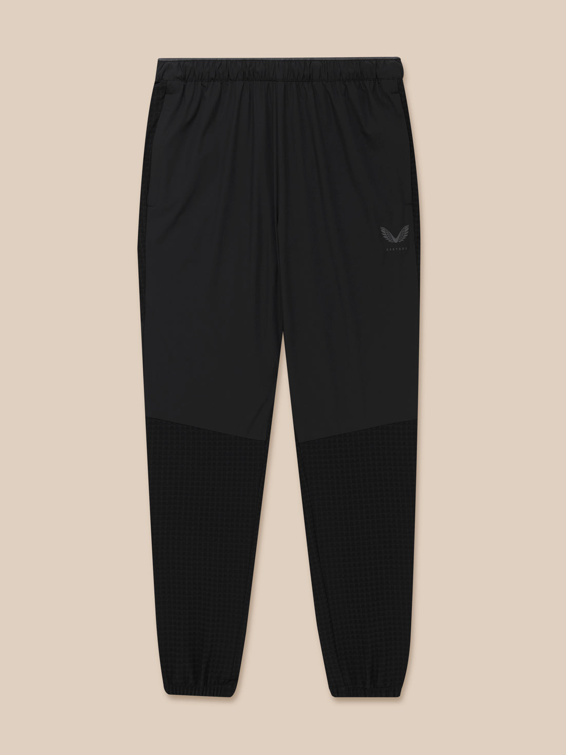 Full-length view of black Flex Winterised Woven Joggers with checkerboard lower legs and Castore emblem.