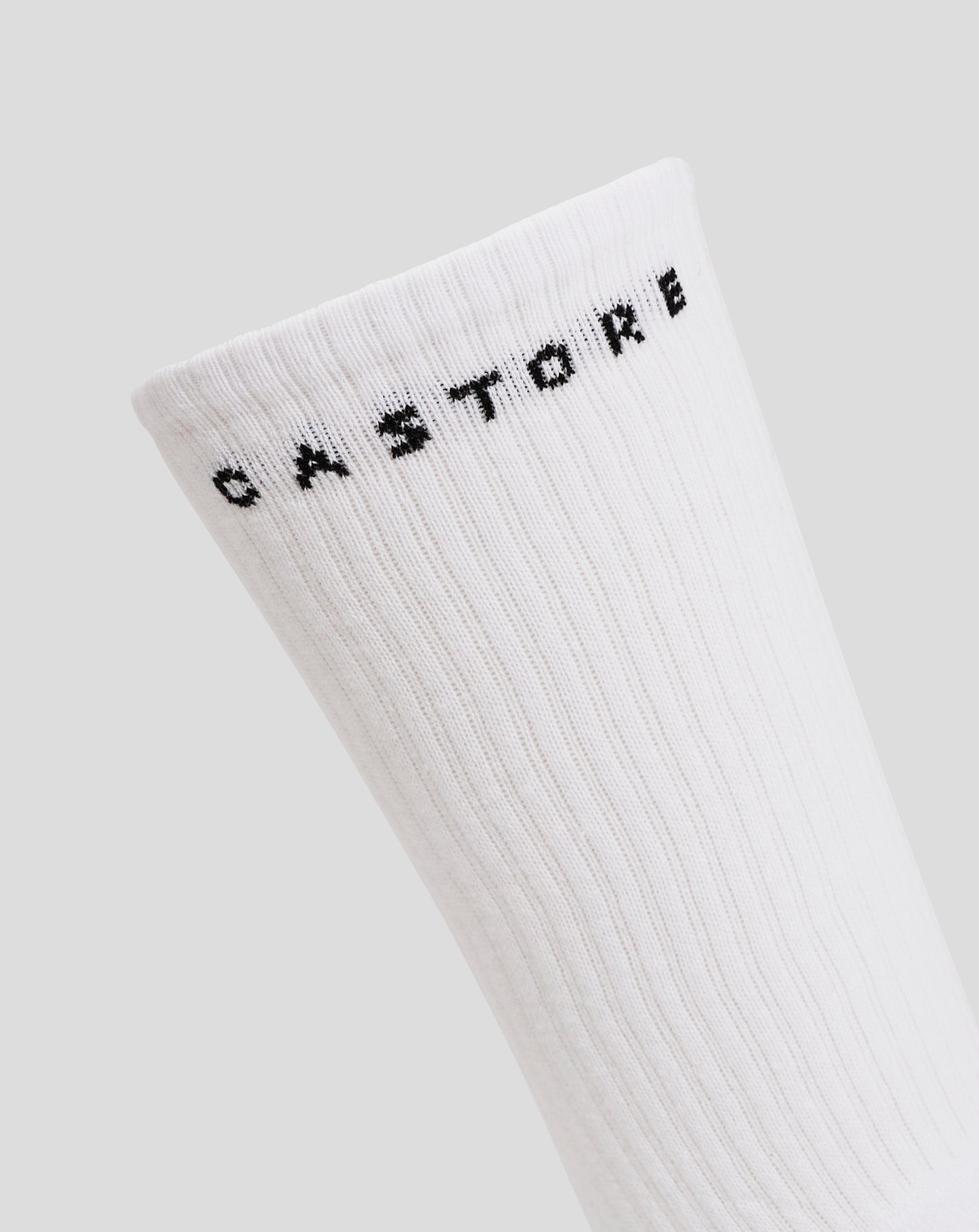 White crew sock cuff with black branding lettering along the edge.