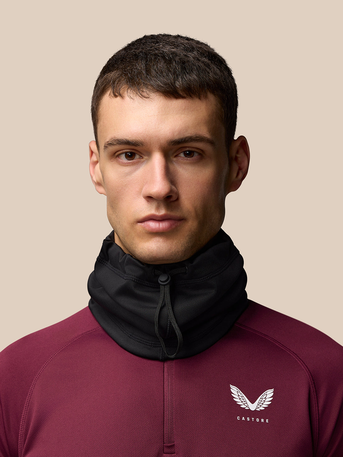 Male model wearing black core snood around the neck during training.