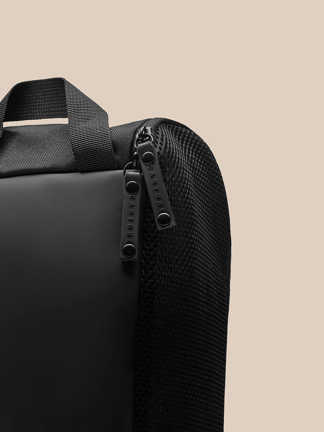 Close-up of black Boot Bag showing top strap, textured polyurethane fabric and branded zipper pulls