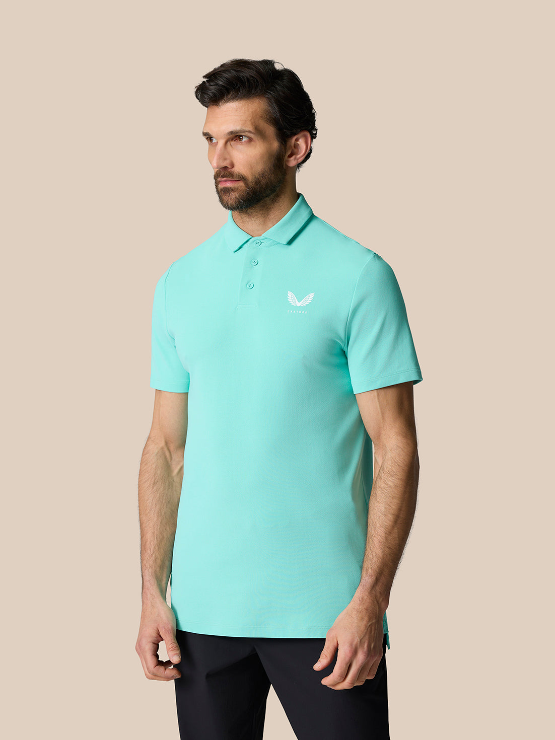 Close up of a man in the light aqua Golf Club Essential Polo showing the polo collar and chest logo.