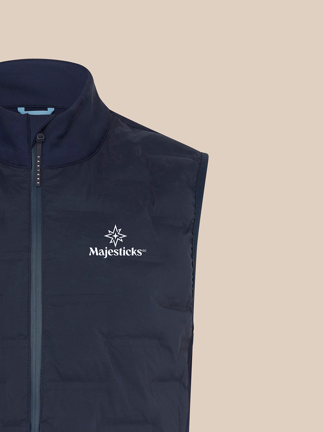 Close-up of navy Majesticks Hybrid Gilet upper chest highlighting branding and zip detail