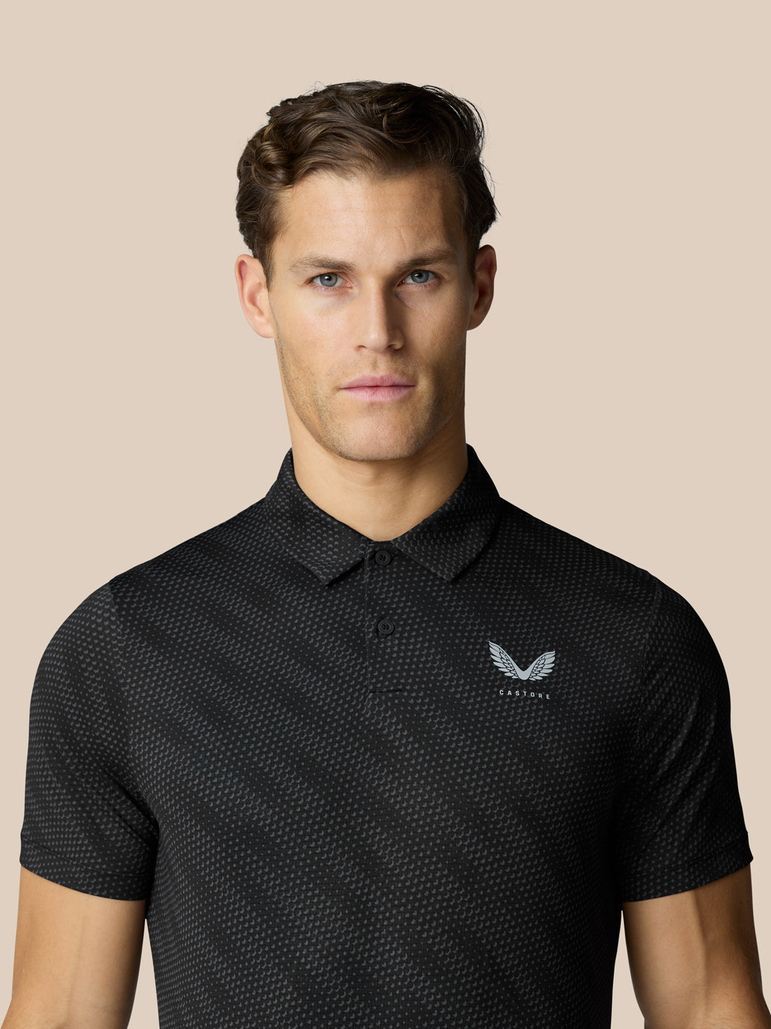 Man wearing black Club Graphic polo with subtle dot pattern and Castore logo on left chest