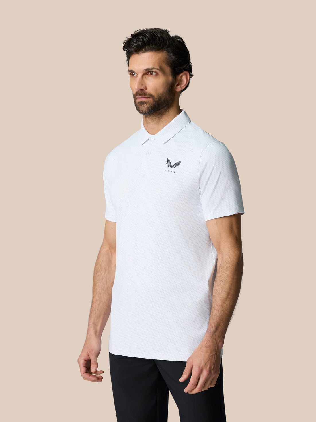 Front three-quarter view of a male model in a white textured polo with Castore logo on the chest.