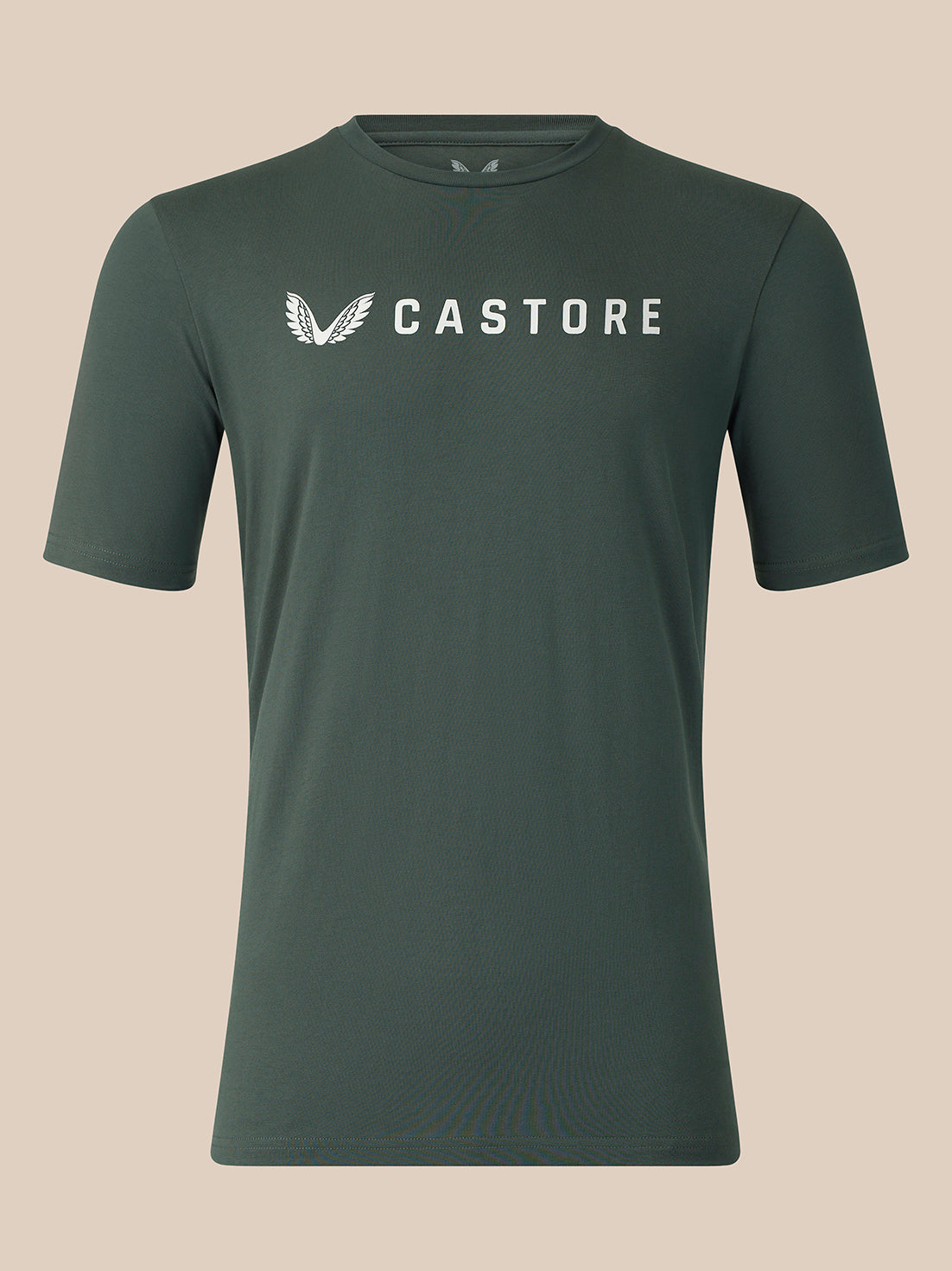 A dark green crewneck t-shirt with a white Castore logo printed on the chest, displayed against a solid beige background.