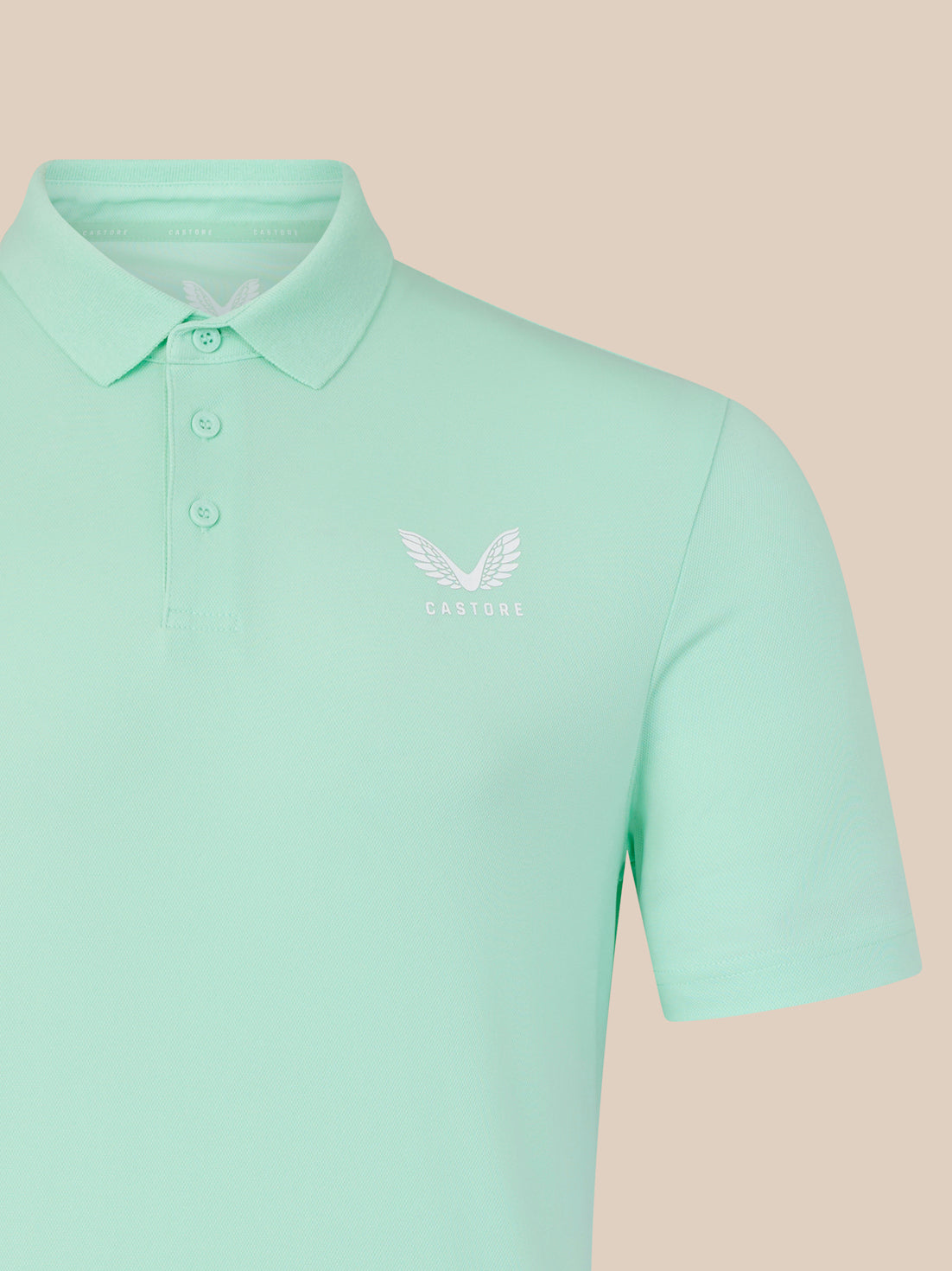 Mint green men's core golf polo with white Castore wing logo on chest.