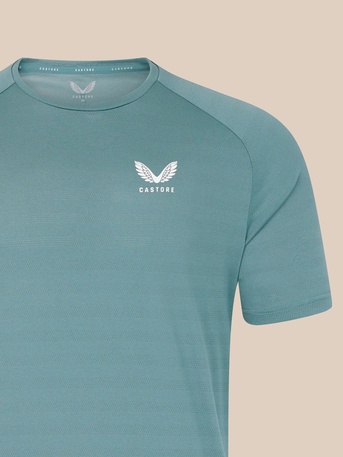 Teal blue short sleeve performance T shirt with a white Castore wing logo on the left chest.