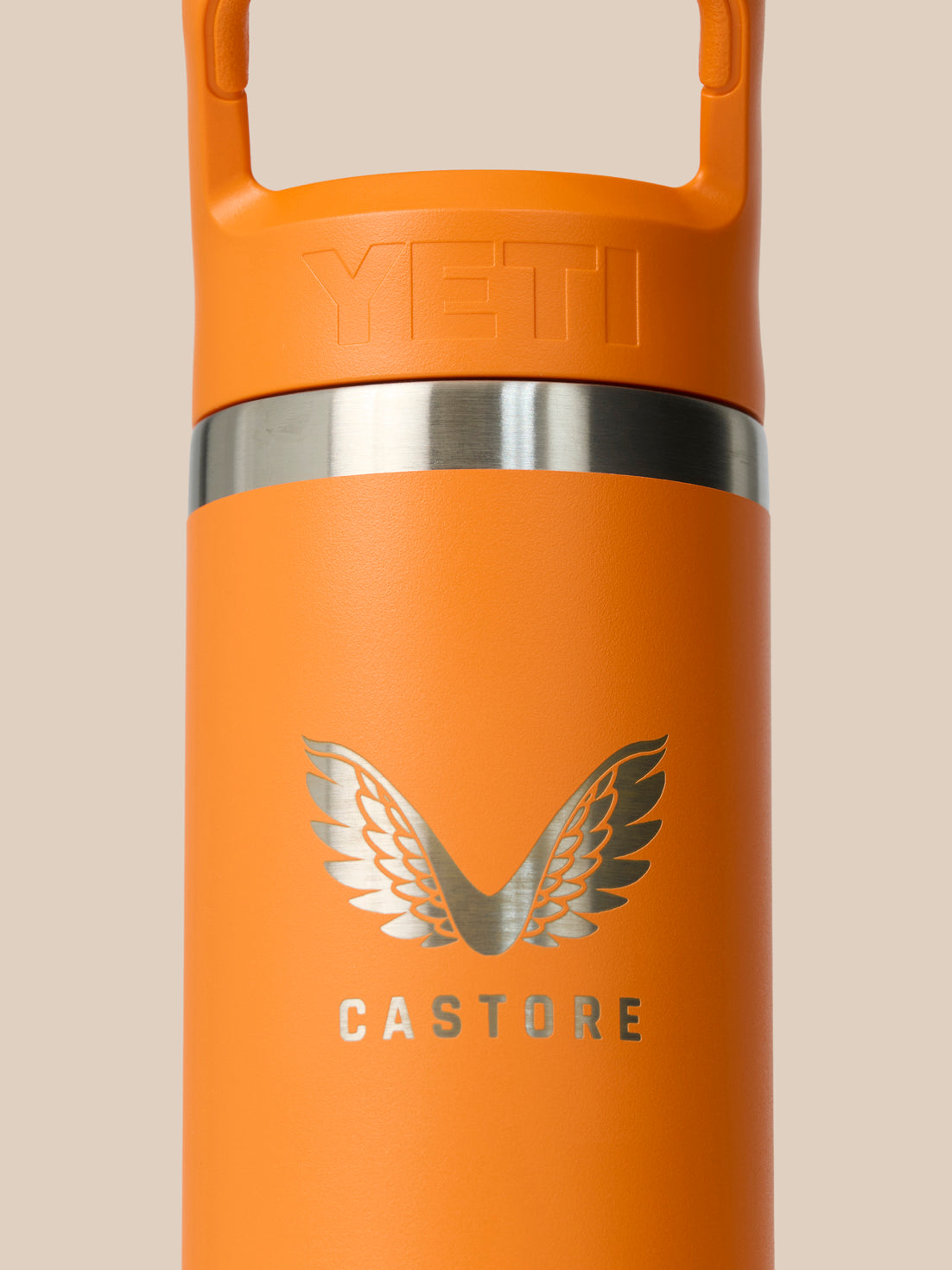 Close-up of orange Rambler top and built-in handle against a neutral background