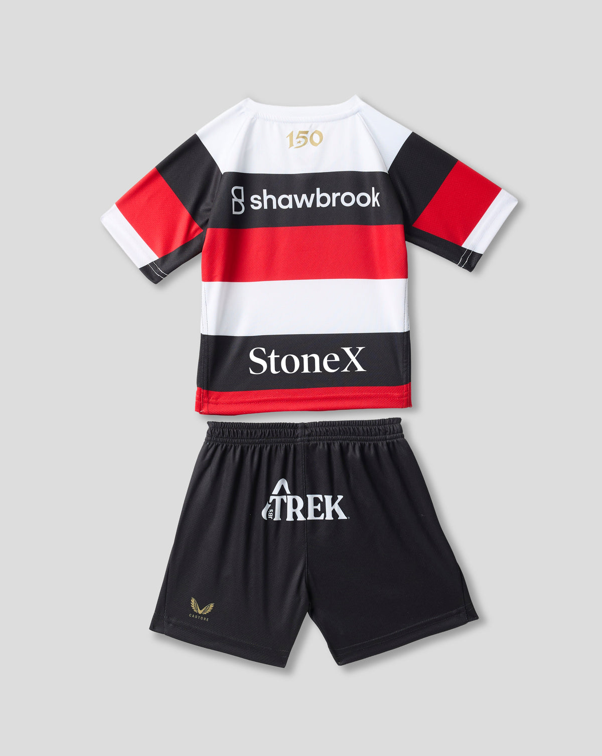 A kids' rugby-style jersey and shorts set laid flat on a light gray background. The jersey is white with bold black and red horizontal stripes, short sleeves, and sponsor logos including Shawbrook and StoneX.