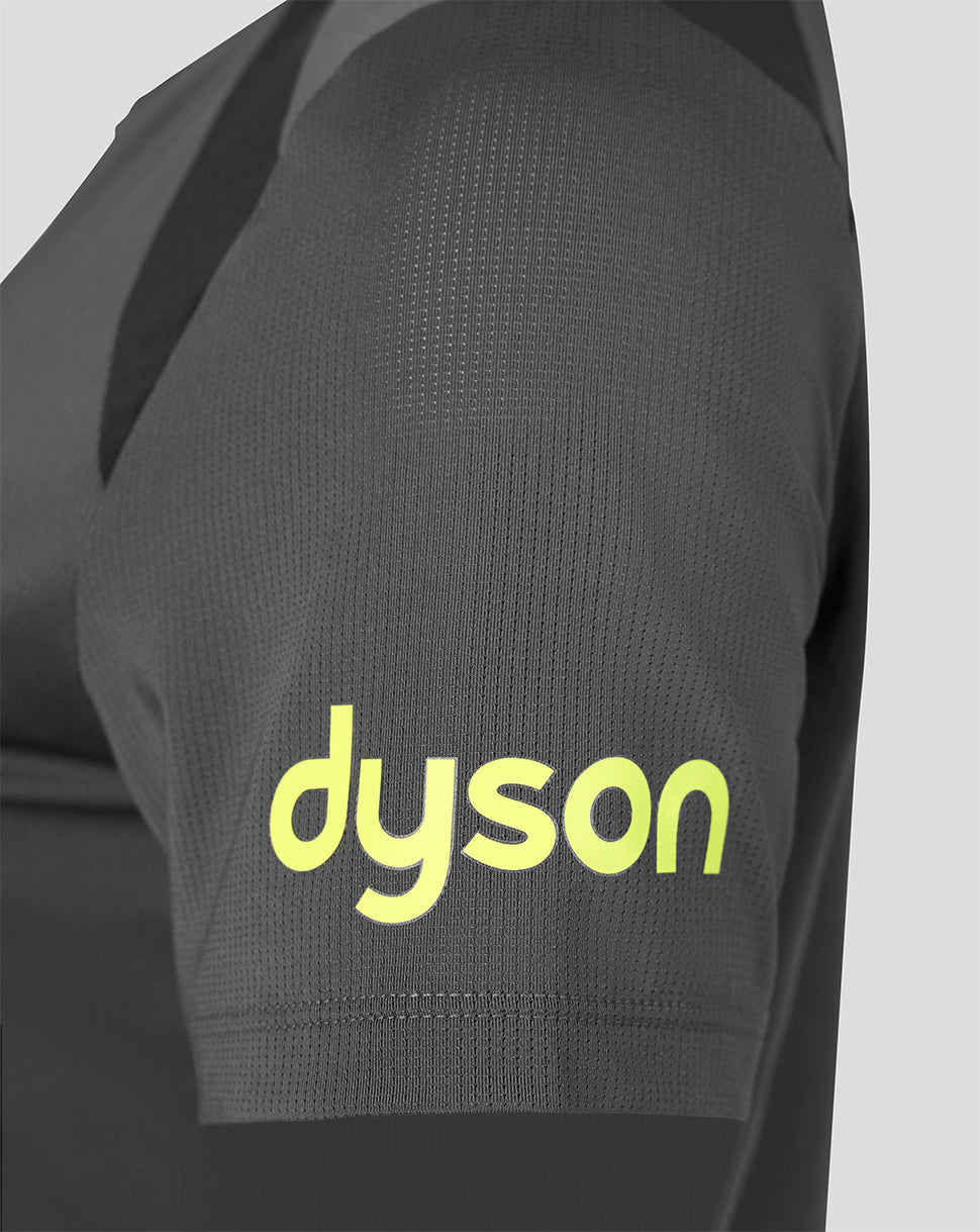 Close-up of a dark gray athletic jersey sleeve featuring a bright yellow-green 'dyson' logo printed on the front, set against a light gray background.