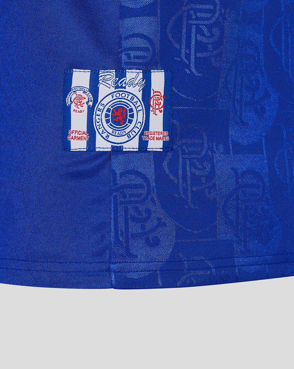 Close-up of Rangers crest patch on blue jersey with a white and blue striped background.