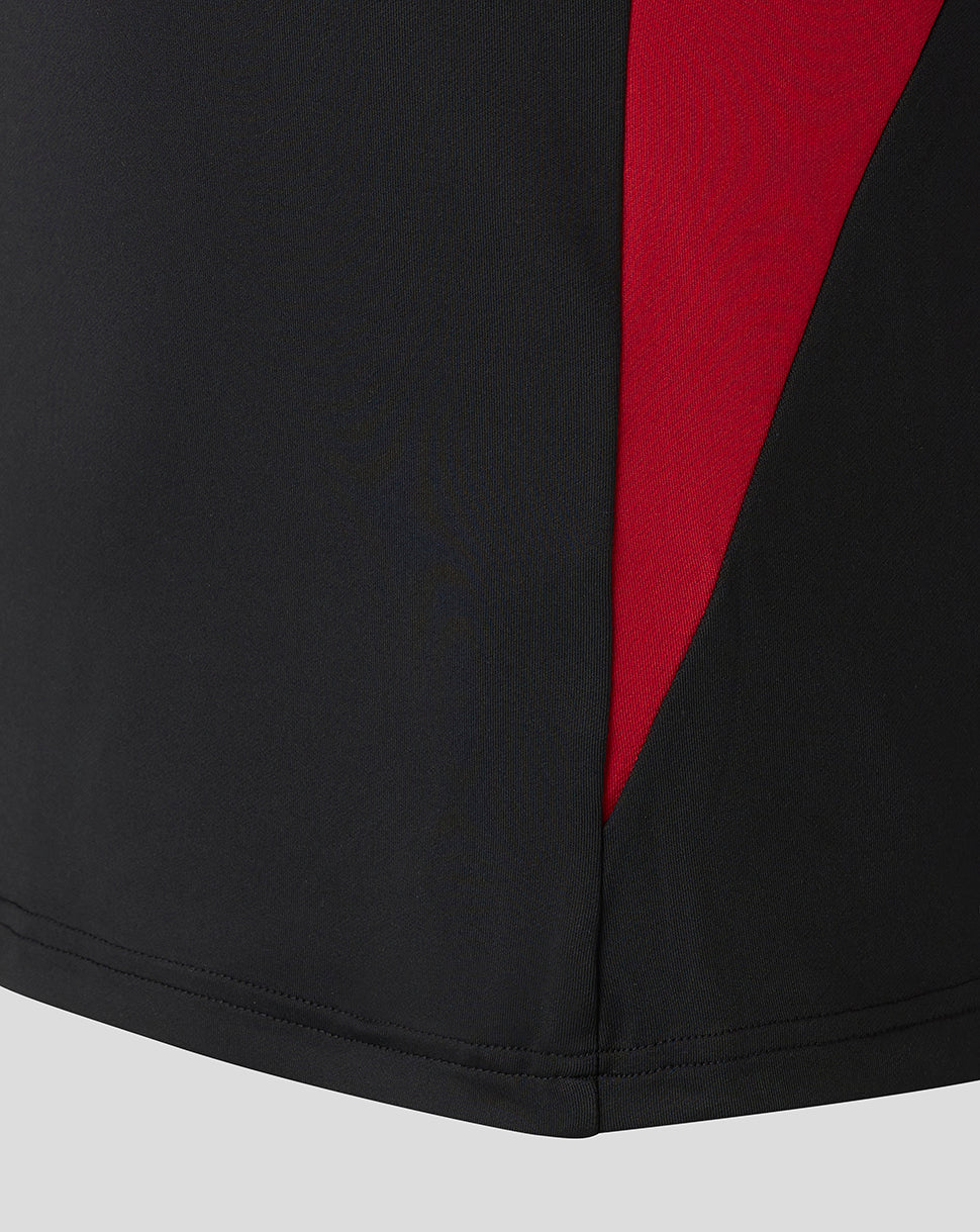 Bottom hem of the black midlayer with a red side panel inset