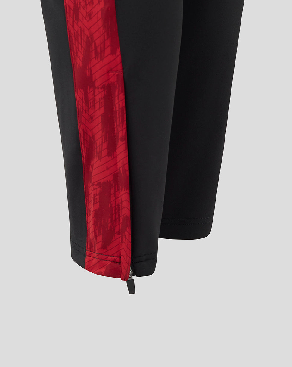 Lower leg of black training pants with a red side stripe and ankle zipper