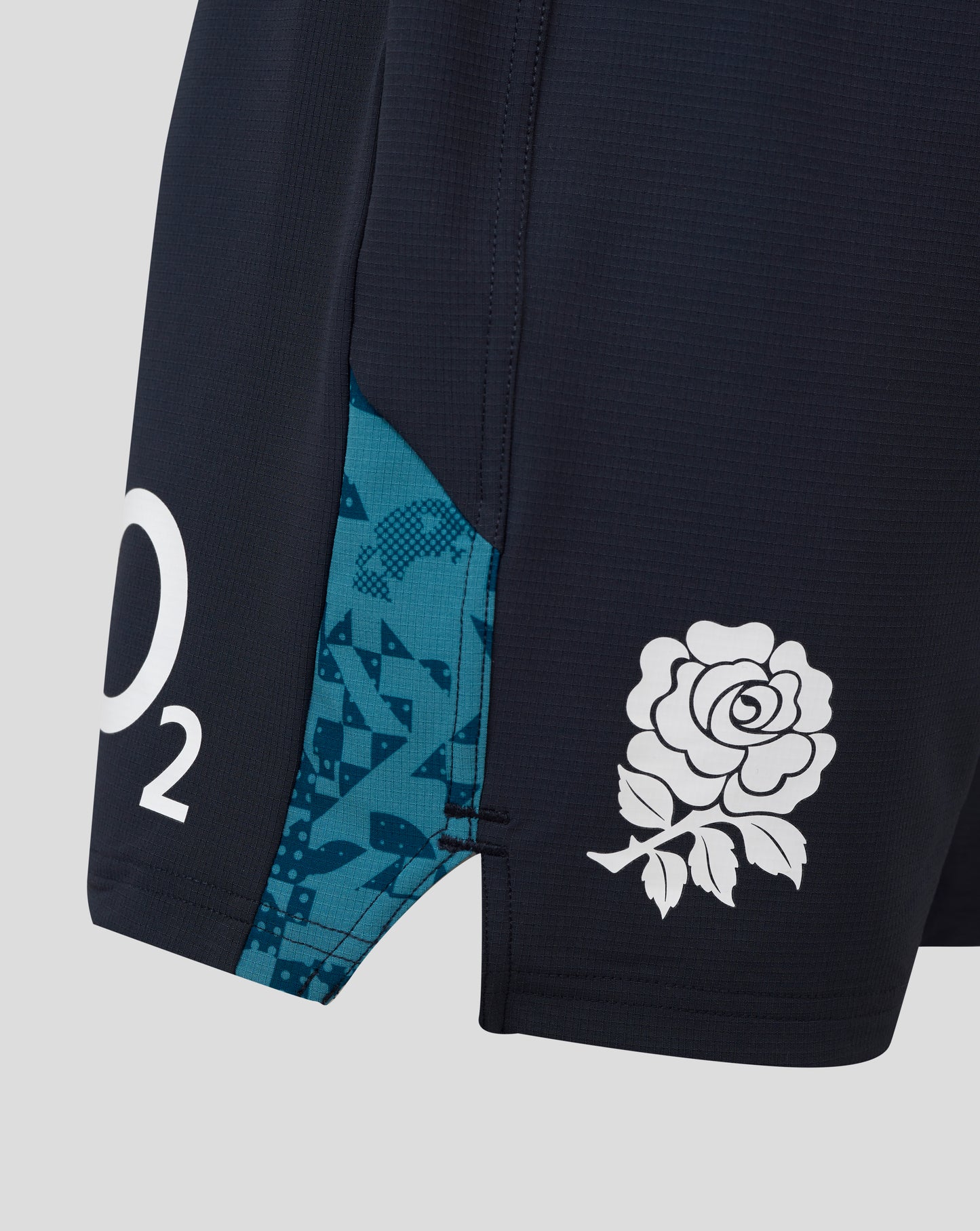 Close-up of England Rugby Women's Contact Shorts navy fabric with teal side panel and white floral emblem.