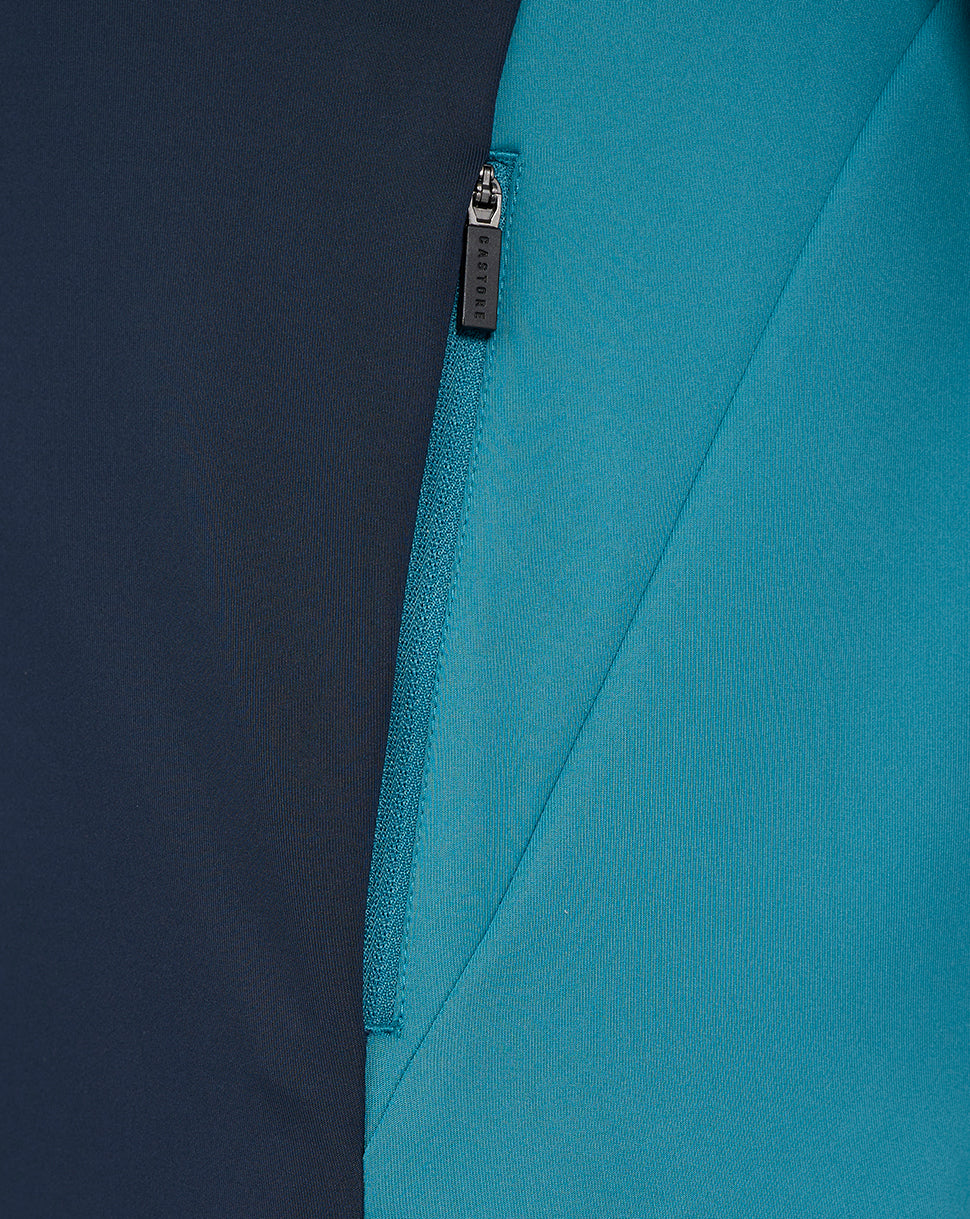 Close-up of navy and teal colorblock fabric with a Castore branded zipper pull