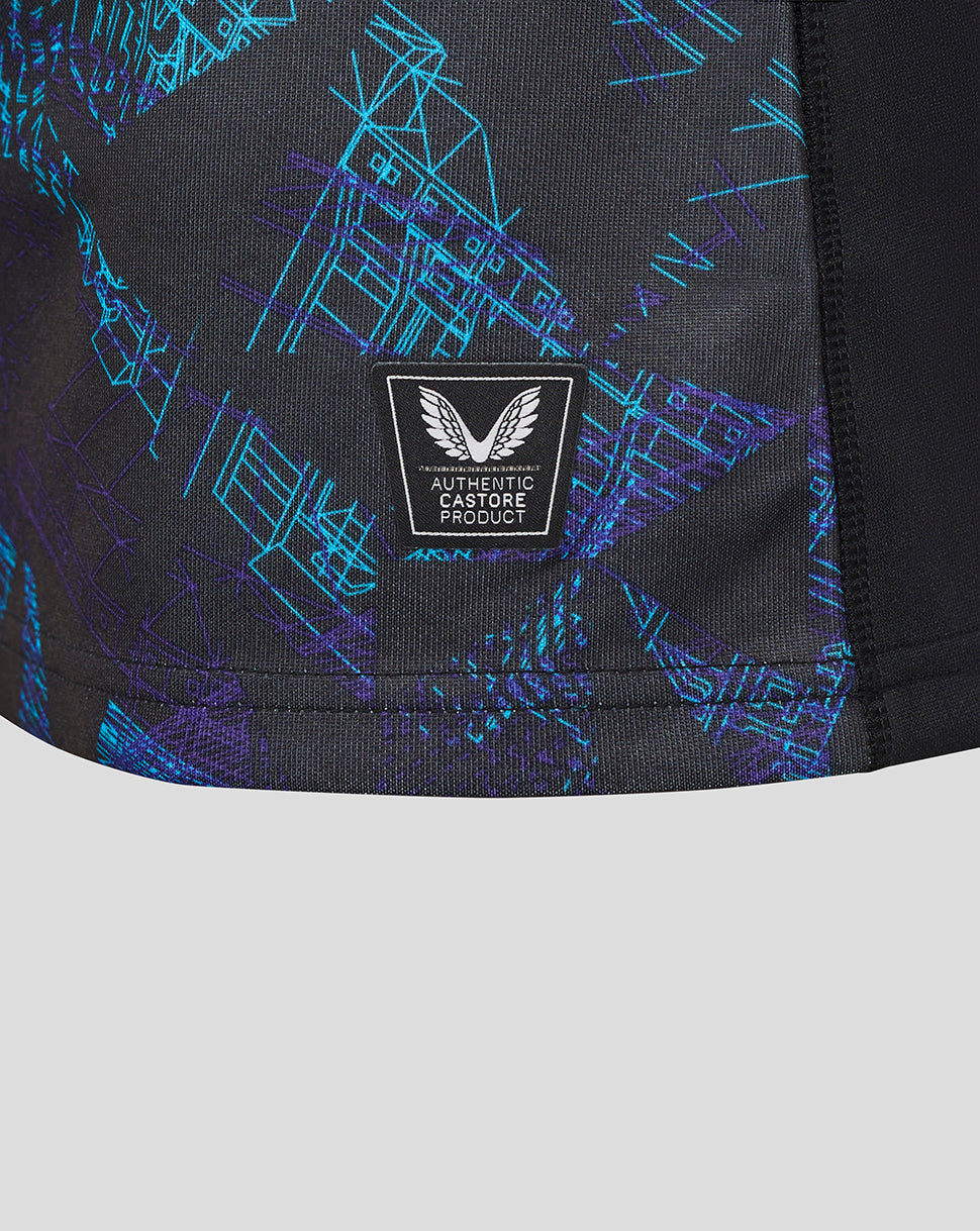 Close-up of lower front of the shirt with blue geometric print and an Authentic Castore Product badge.
