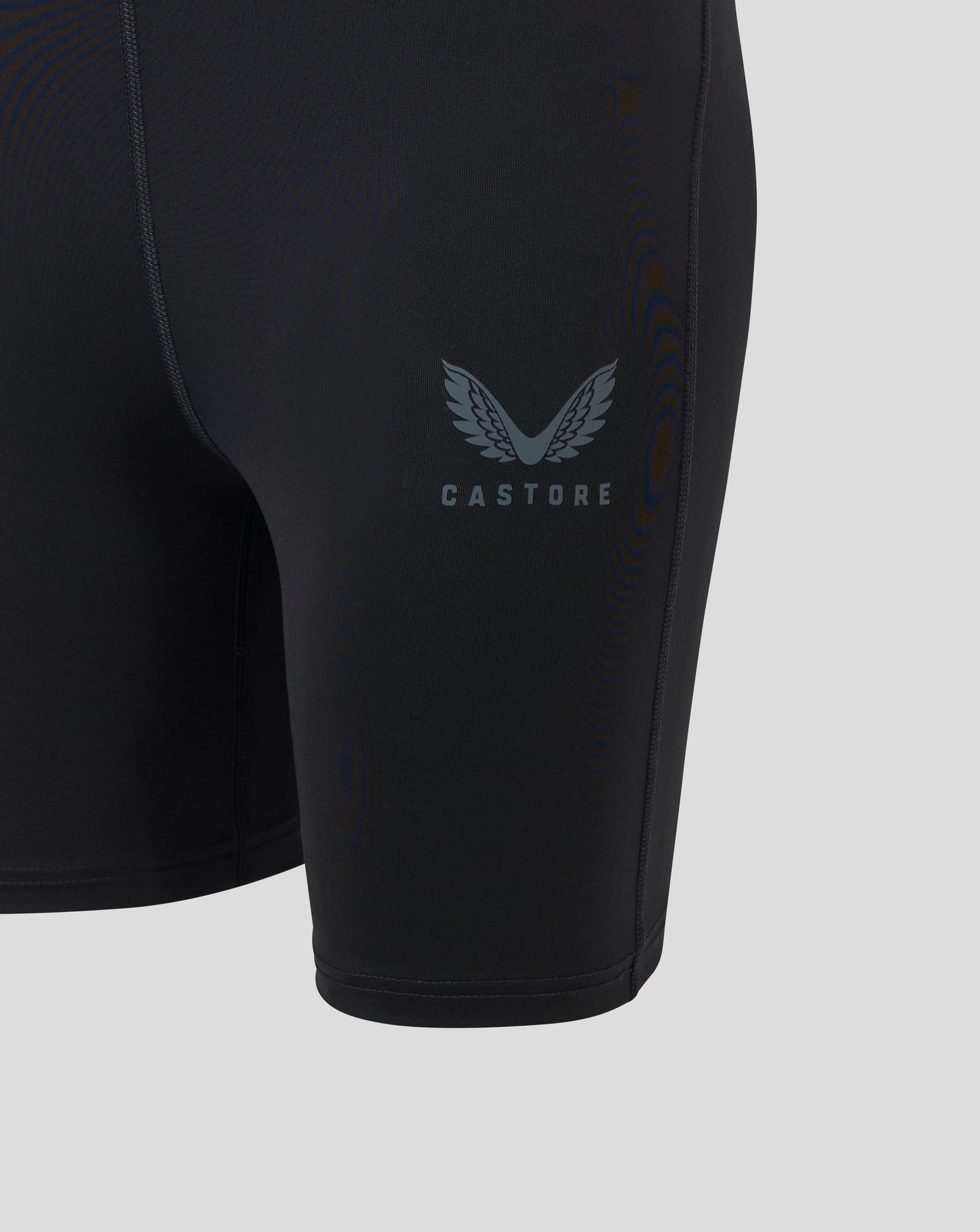 Womens Baselayer Short in black Caviar shown on the leg with a Castore logo and visible flatlock seams