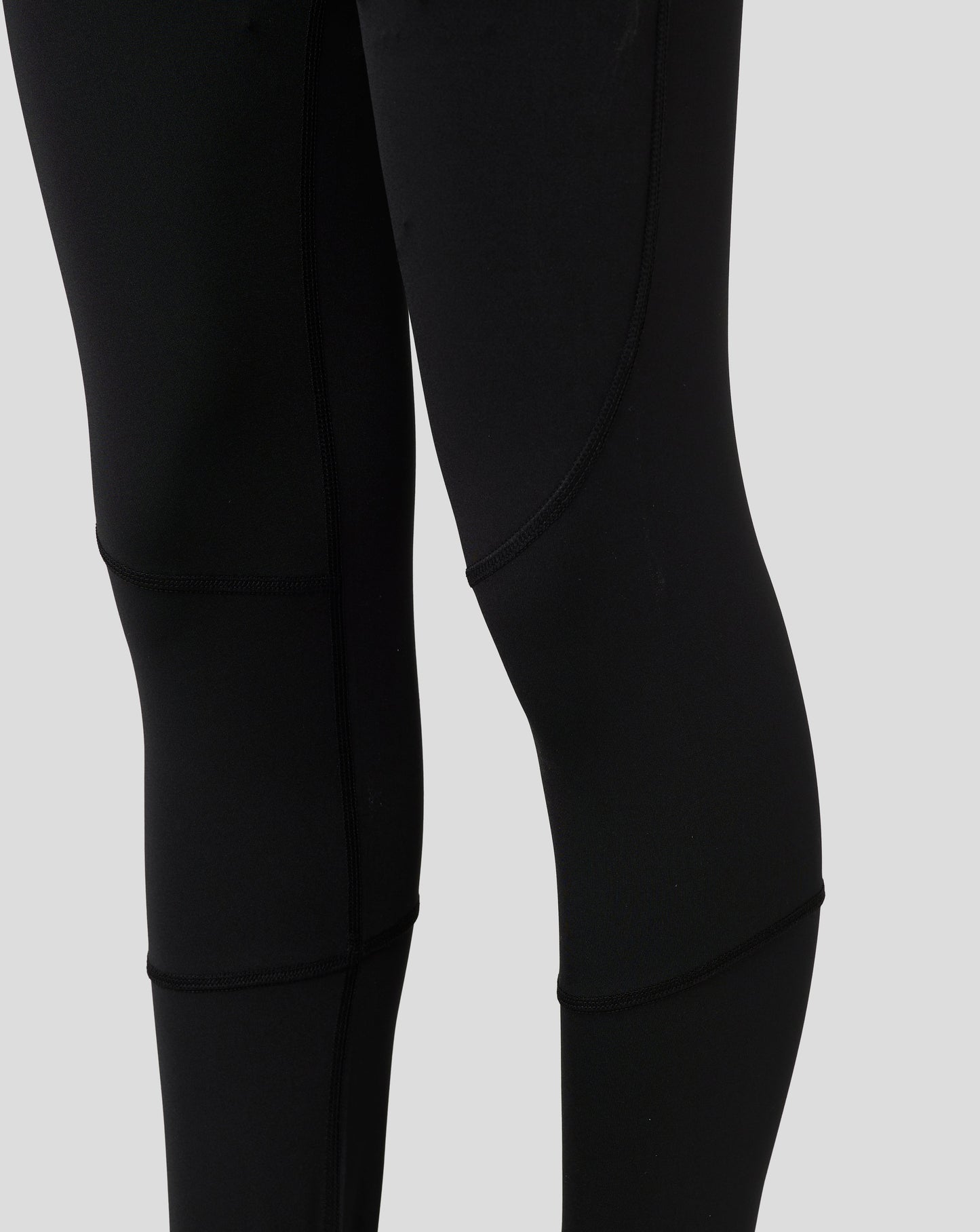 Close up of black Baselayer Legging fabric showing paneling and flatlock seams