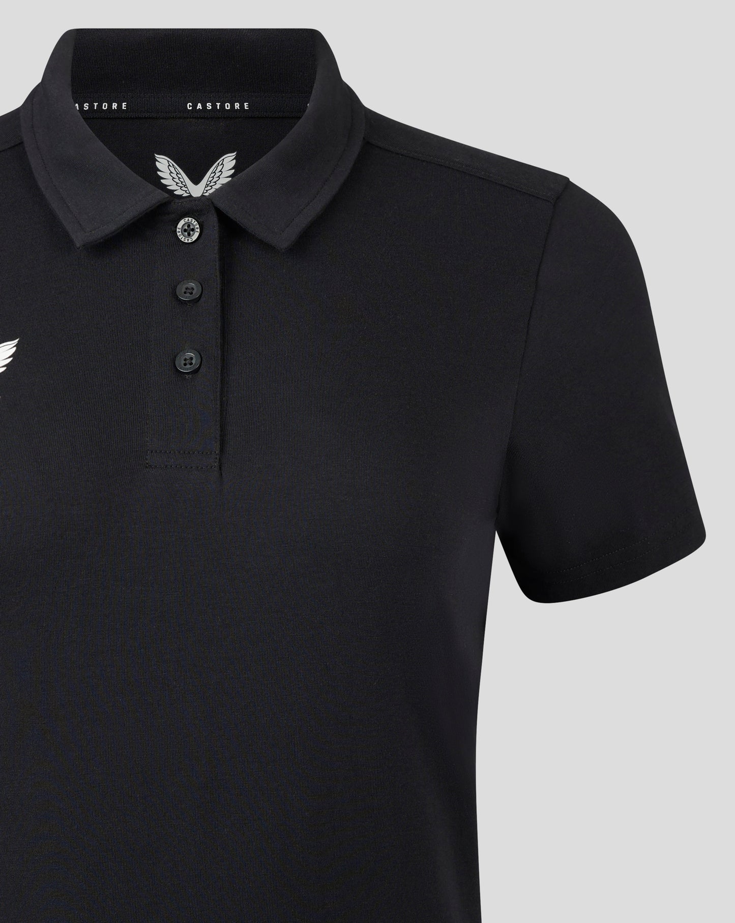 Front view of black polo featuring three button placket and white Castore crest on the left chest.