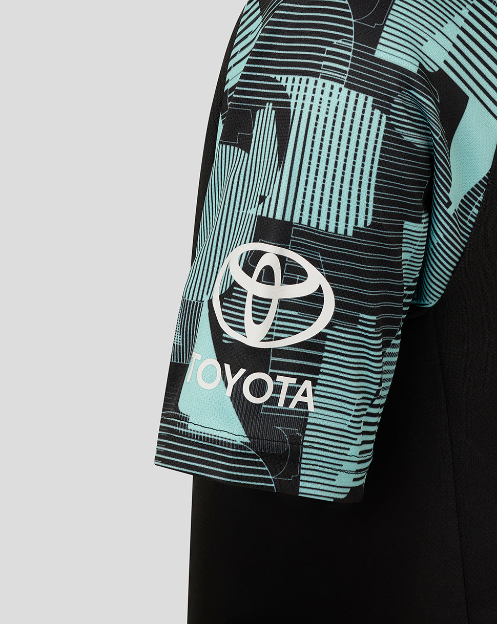Close up of teal graphic sleeve with Toyota logo on junior Ashes training tee