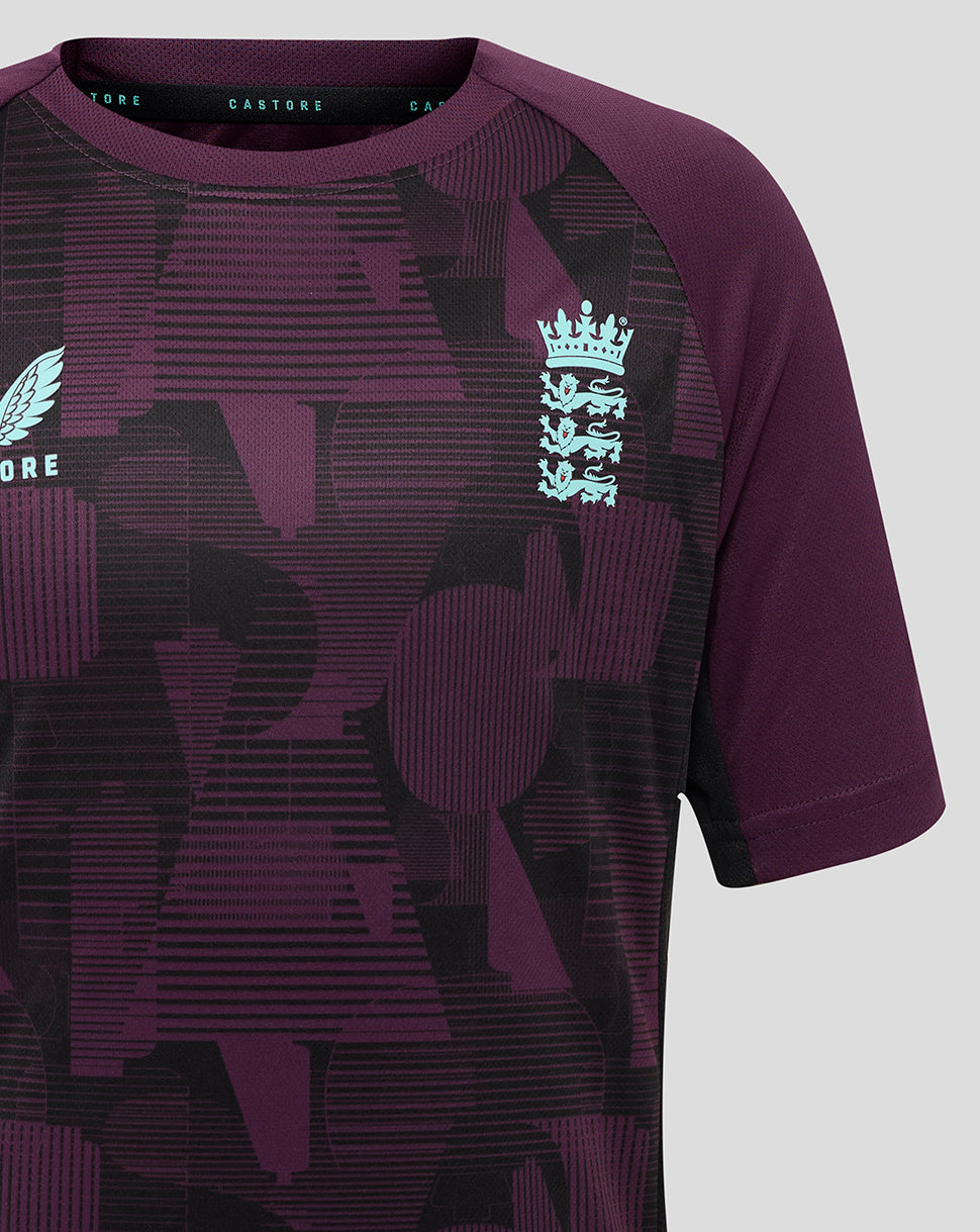 Chest view of England cricket training junior short sleeve tee showing light blue England crest on purple geometric print