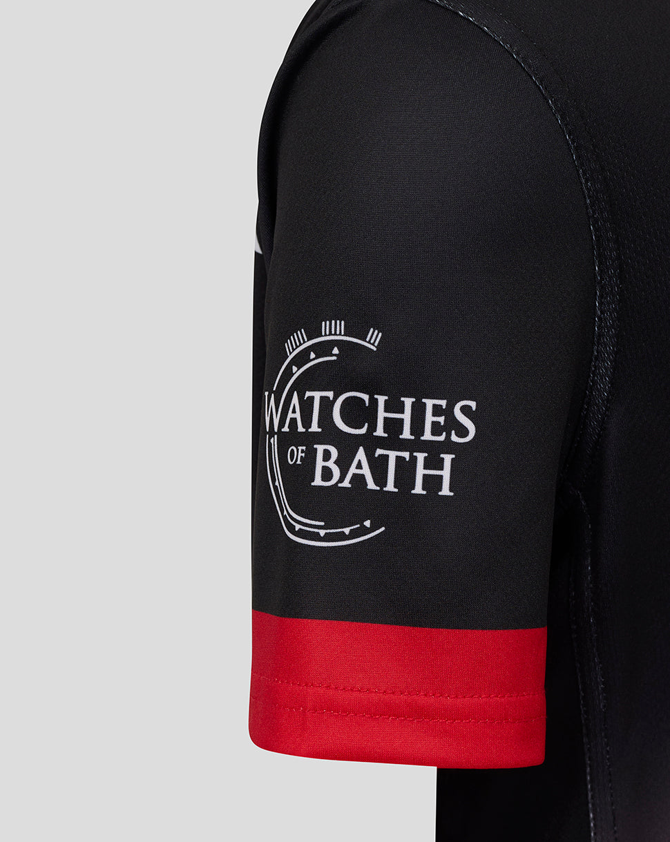 Close-up of black sleeve with red cuff and Watches of Bath logo on Saracens junior shirt
