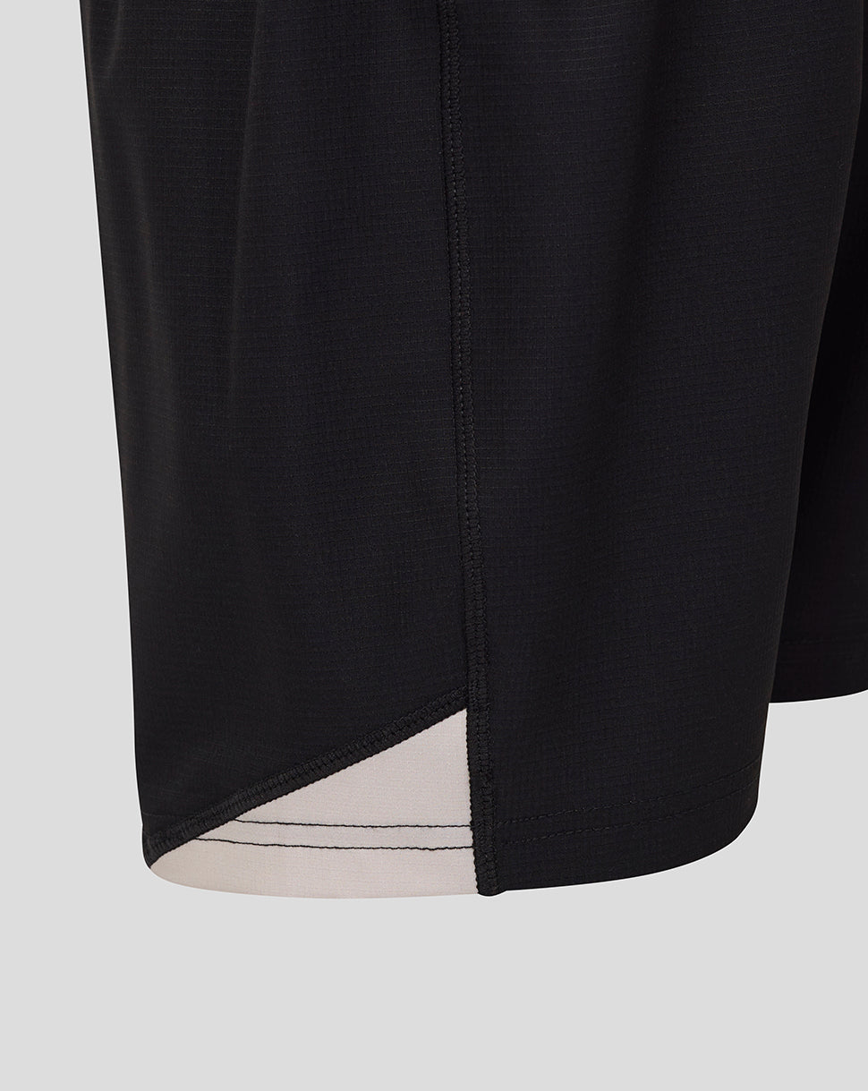 Close-up of the black Saracens junior replica away shorts hem with beige trim