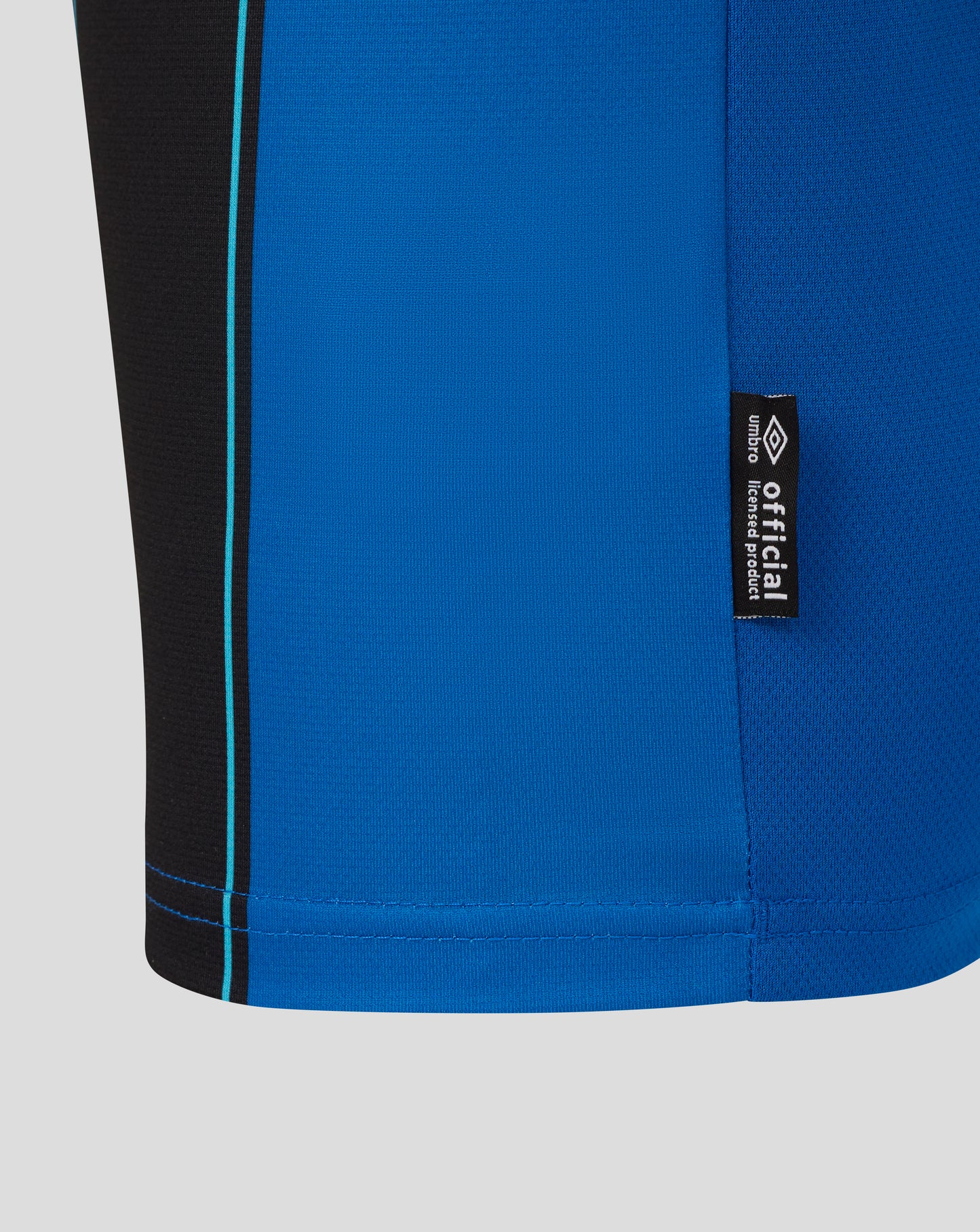 Close-up of AFC Bournemouth junior away shirt showing blue fabric, a black side panel with turquoise stripe, and a vertical Umbro tag.