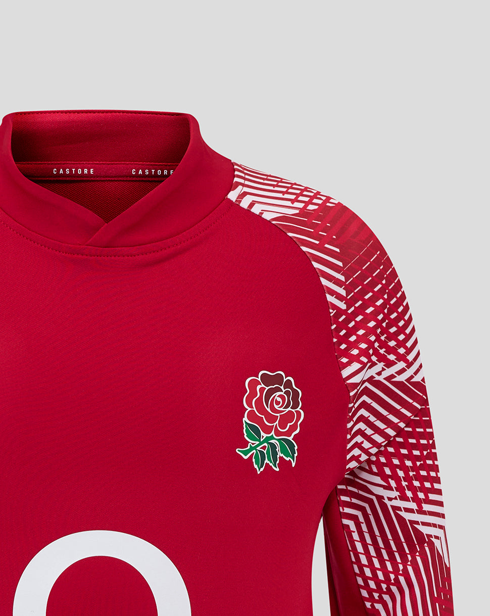 Detail shot of the red England Rugby junior drill top with a white rose crest on the chest and a geometric pattern on the sleeve.