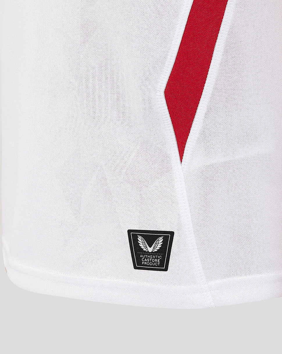 Close up of the shirt front lower section showing a red diagonal stripe and Castore authenticity patch at the hem.