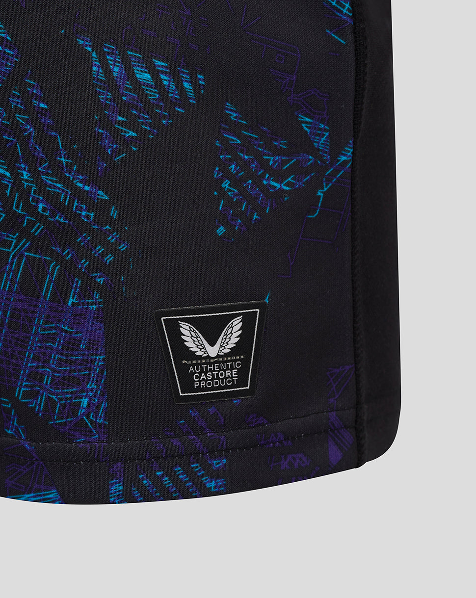 Close up of the lower side of the black shirt showing teal side panel and an authentic Castore product badge.