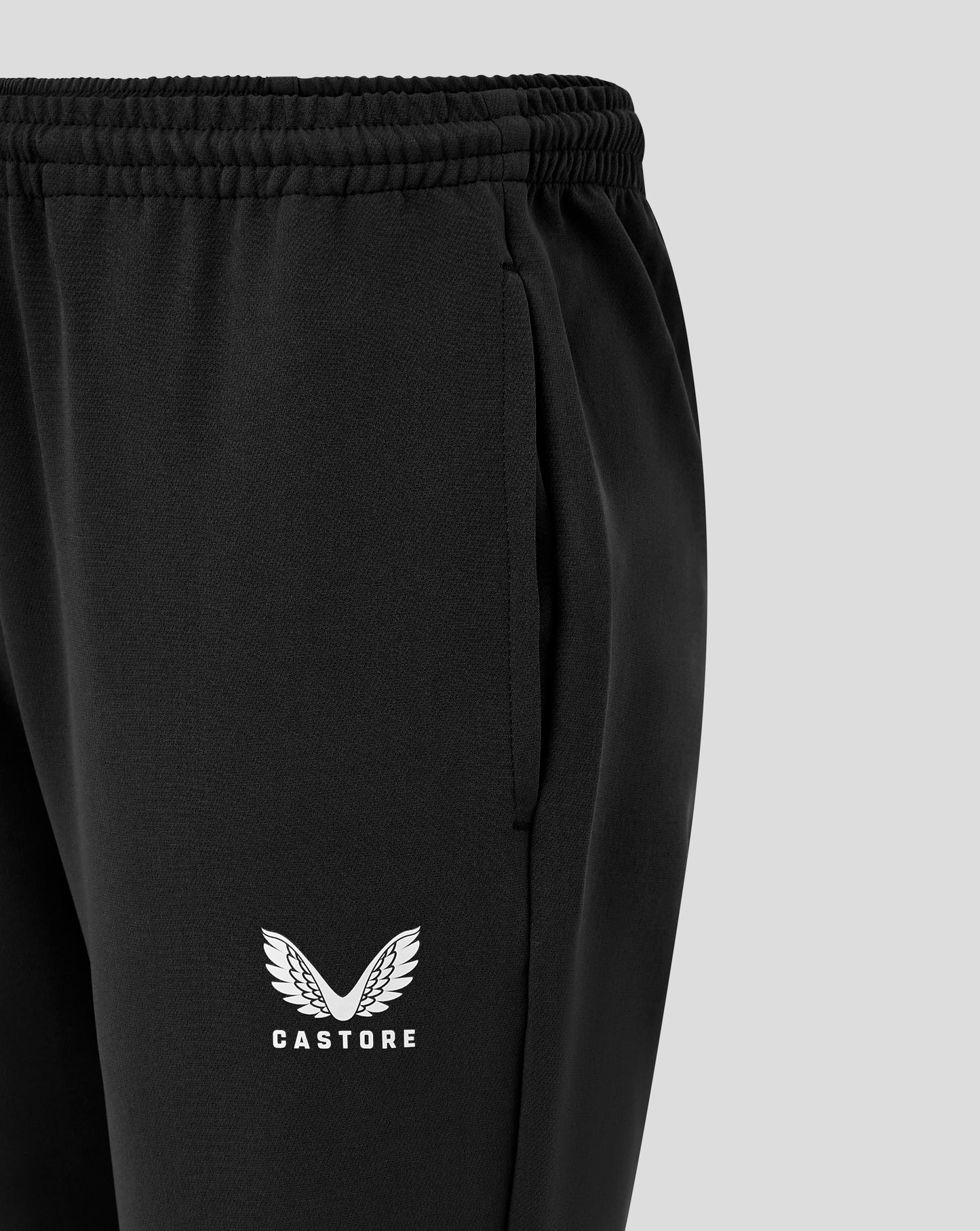 Side view of black Junior Track Pant showing logo at the thigh