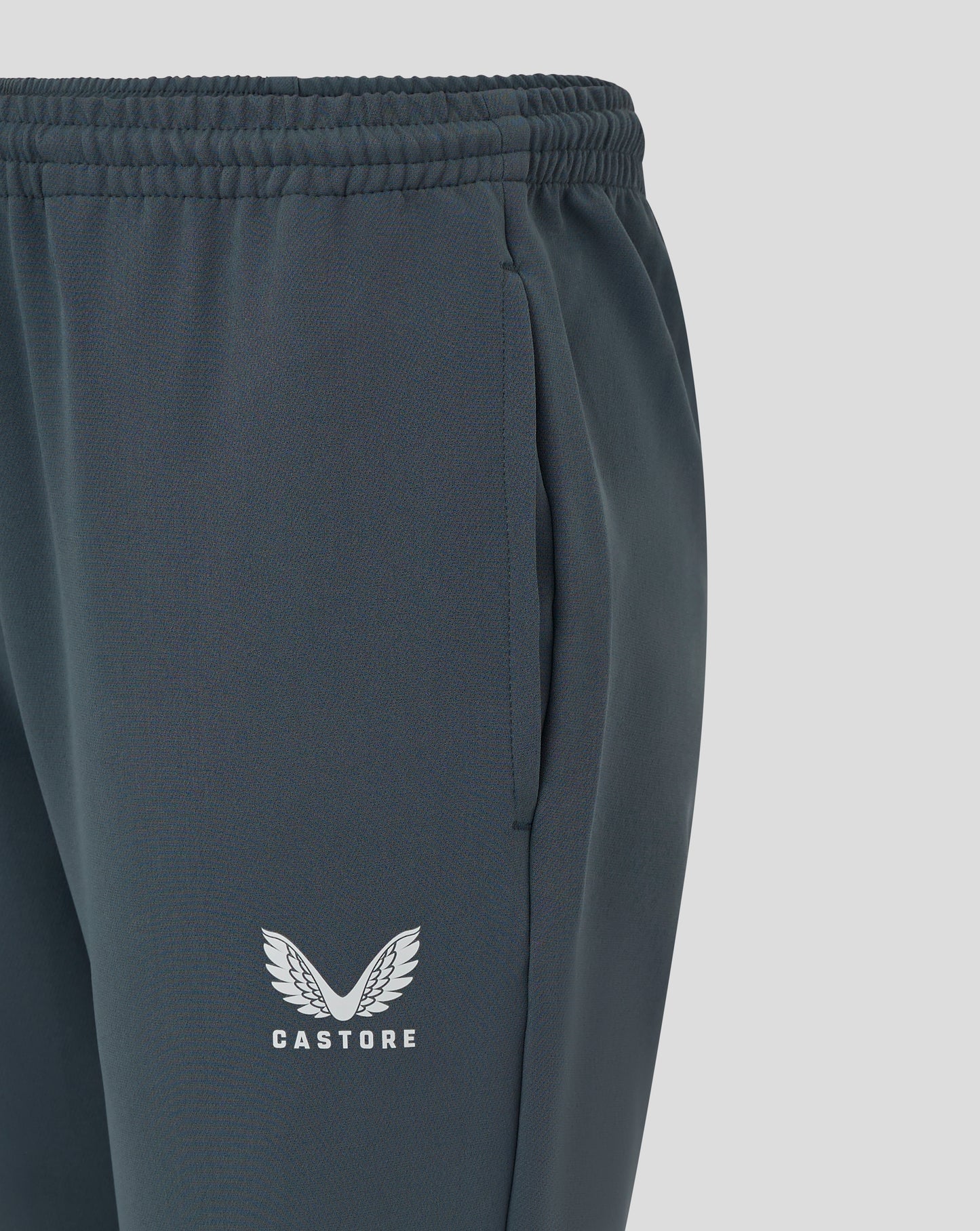 Close up of waistband and side pocket on dark slate track pants showing stitching and fabric texture