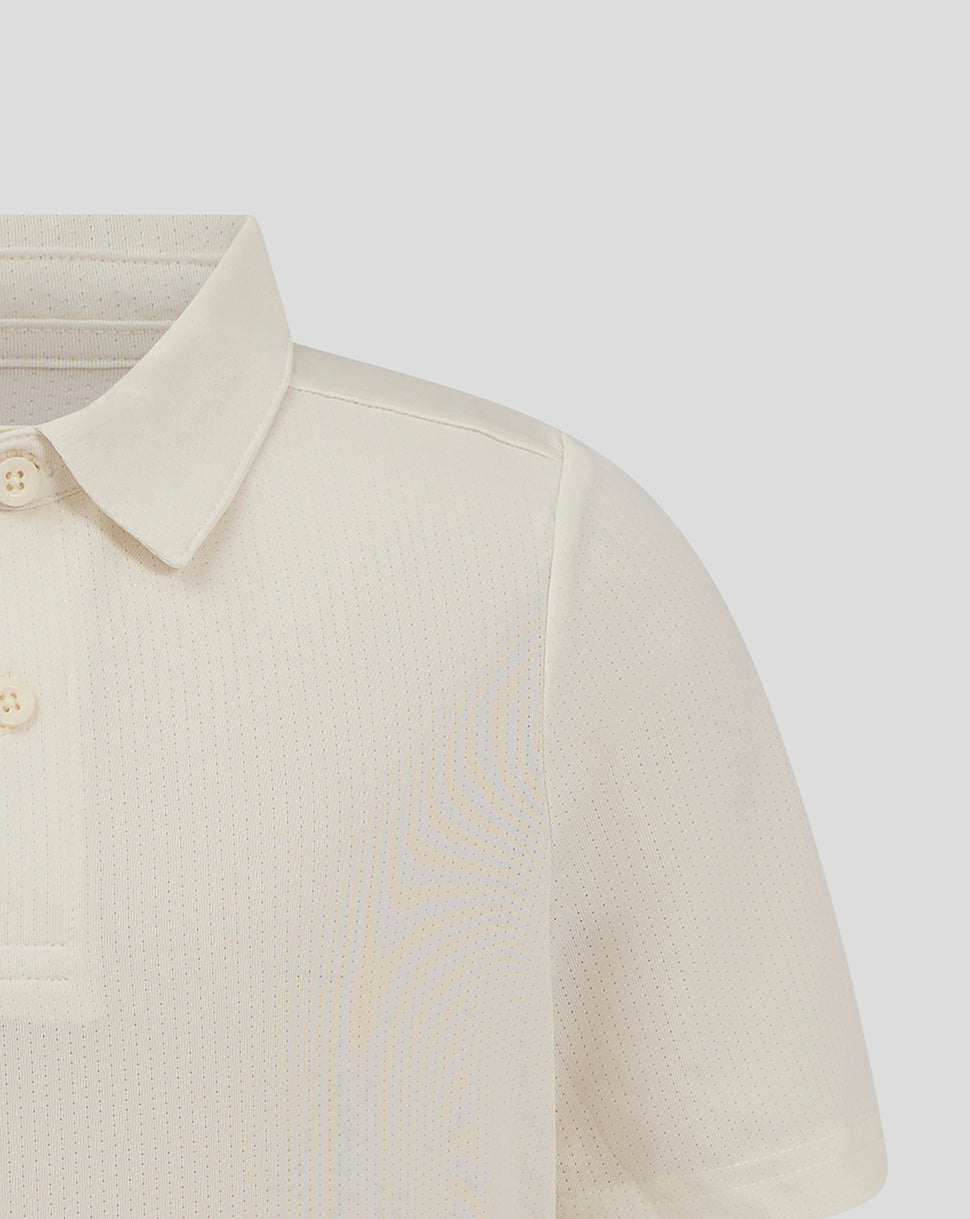 Shoulder and chest close-up of Cannoli Cream Junior Cricket Tech Playing Shirt featuring forward shoulder seam and Castore branding.